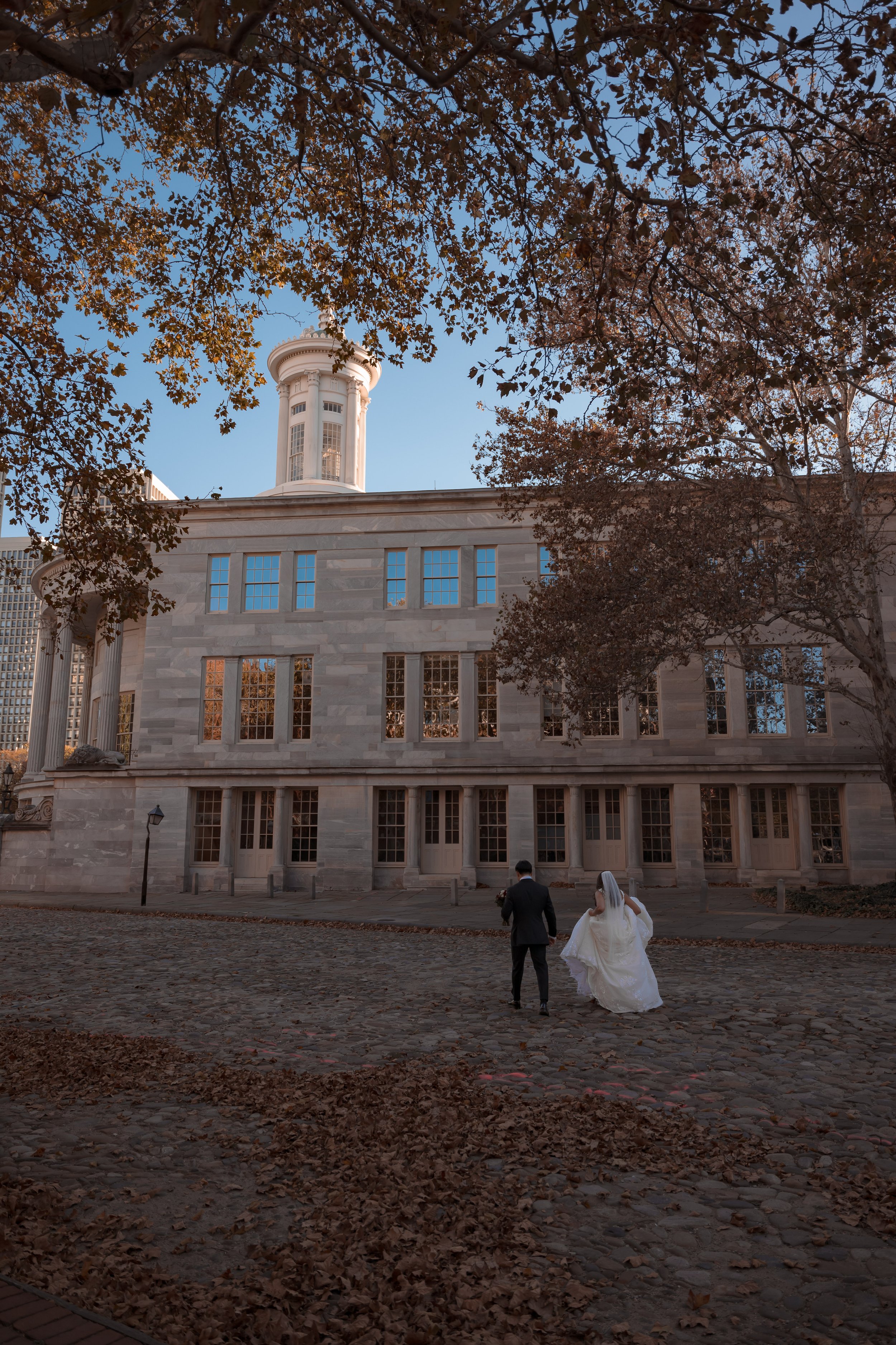 Newlyweds' Journey Begins: Stroll Away from the Camera at the Exchange Merchant Building, Philadelphia