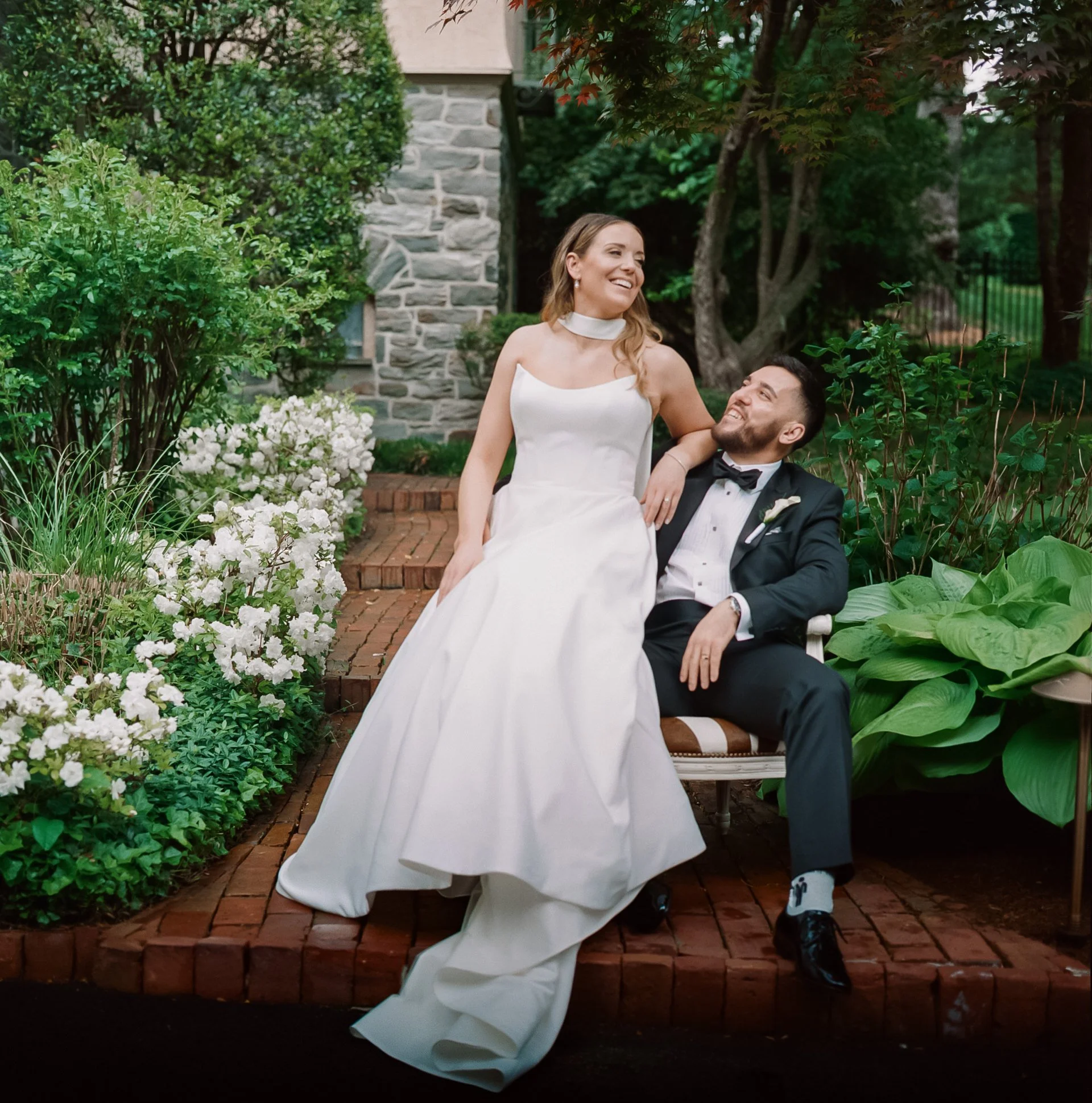 Color film wedding portrait of a bride and groom laughing together in a garden