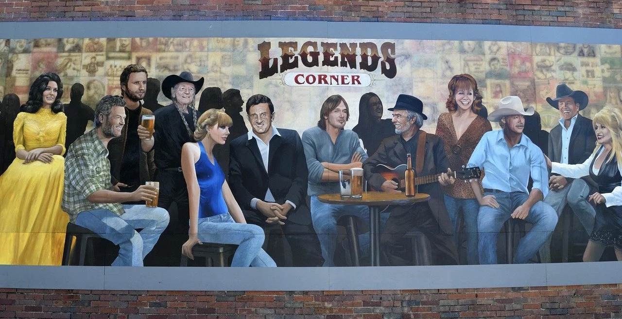 Large mural depicting diverse people sitting and standing, some holding drinks and one playing a guitar, with the text 'Legends Corner' on the wall behind them.