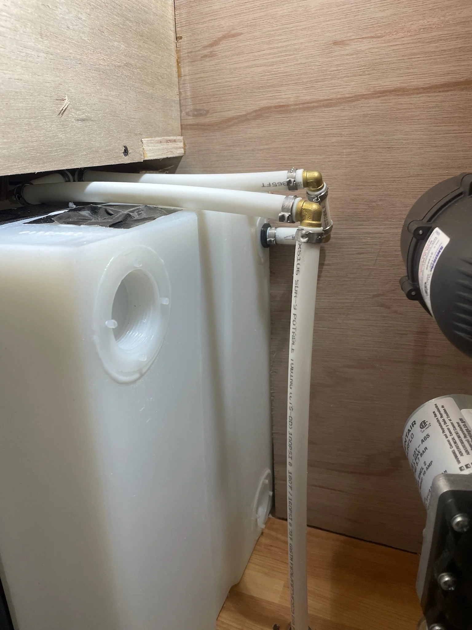 Plastic water tank with connected plumbing pipes