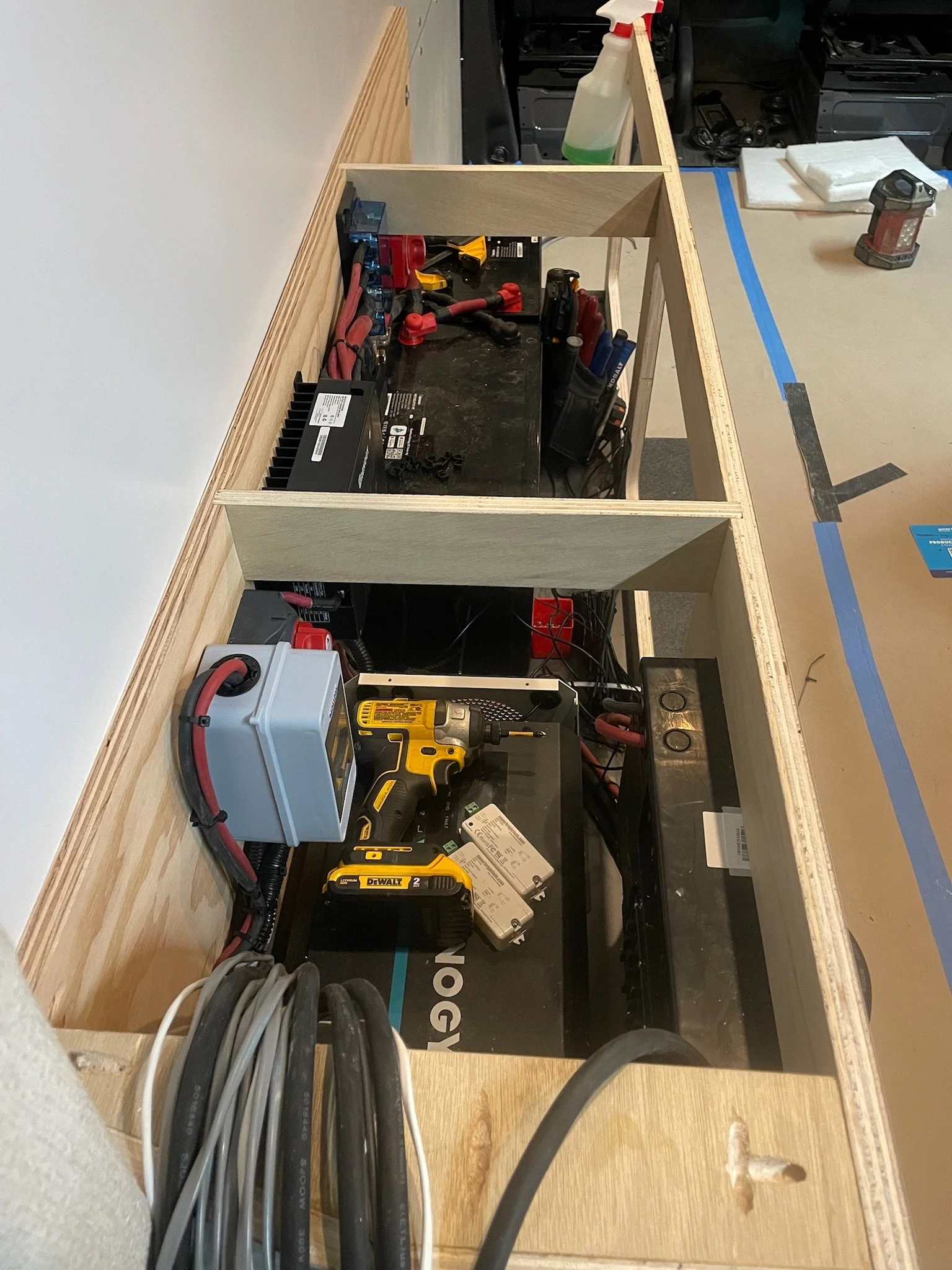 Workbench with tools, cables, and electronic components in a workshop setting.