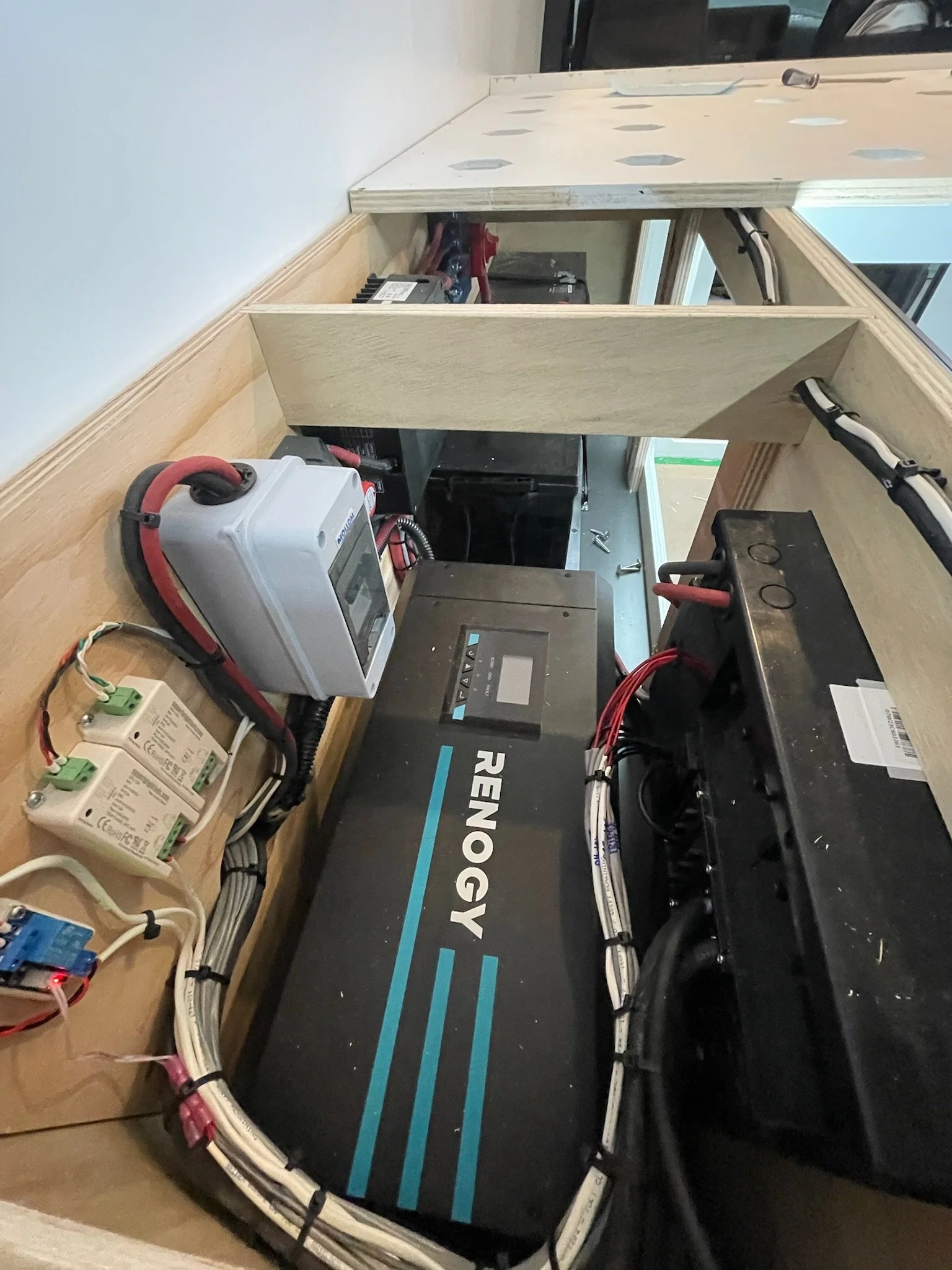 RV electrical system with Renogy components, including inverter, wiring, and breaker panels.