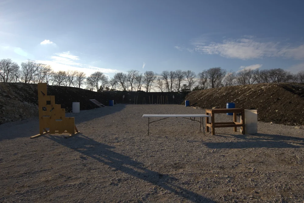 Tactical bay with target stands, tables, and barrels
