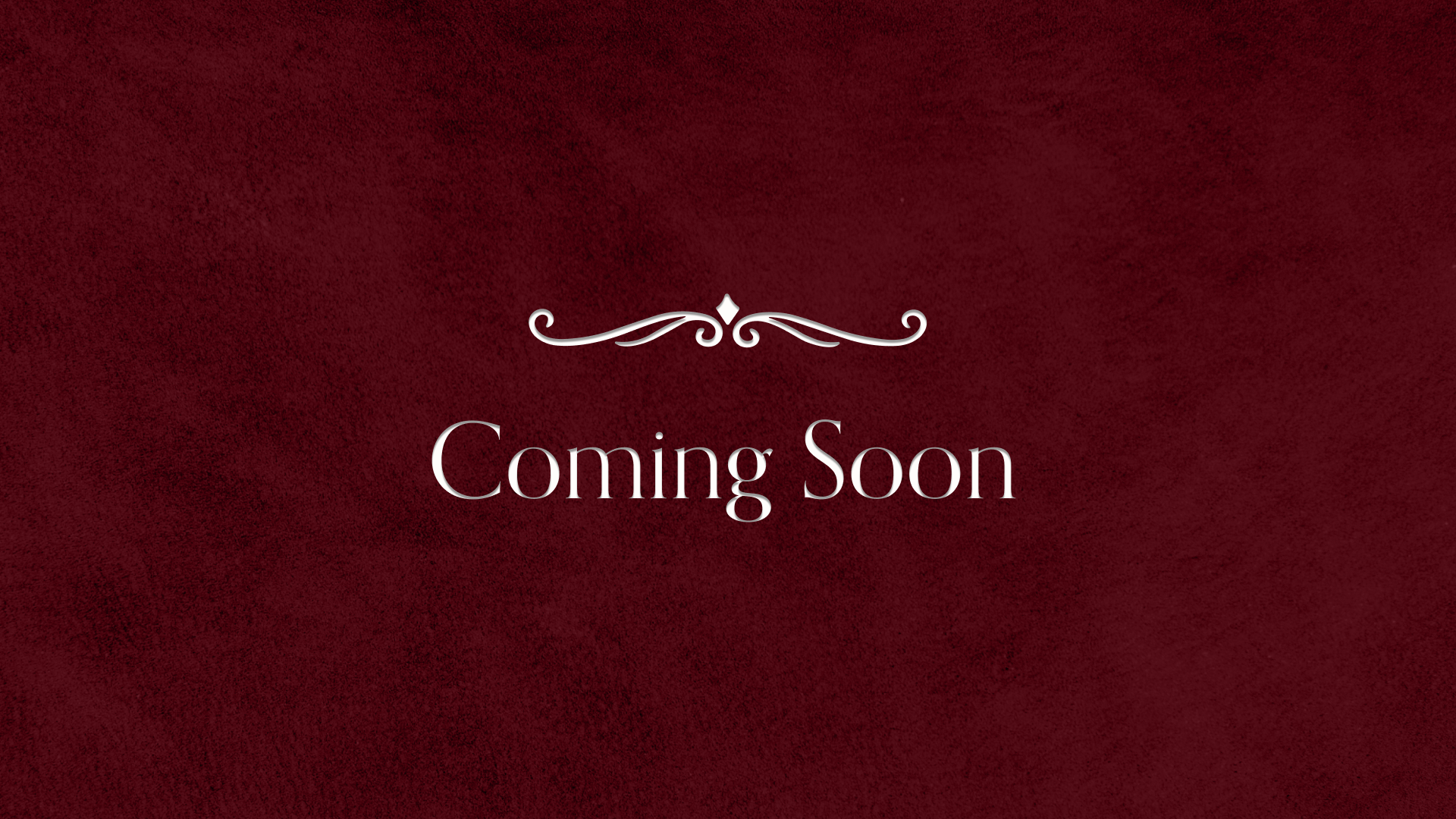 A maroon background with the words "Coming Soon" in elegant white font, with a decorative swirl design above the text.