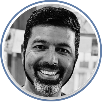 Black-and-white headshot of a smiling man with short dark hair
