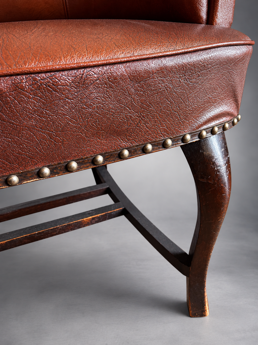 Vintage Leather Chair Detail with Brass Studs.png