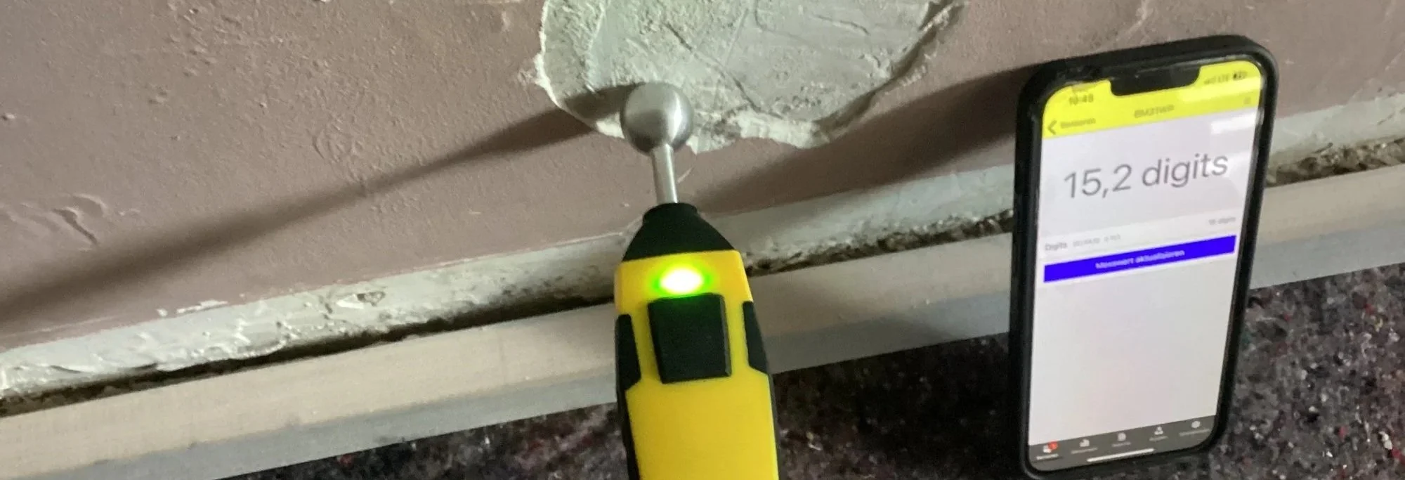 Trotec-Feuchtesensor an einer Wand mit digital dokumentiertem Messwert