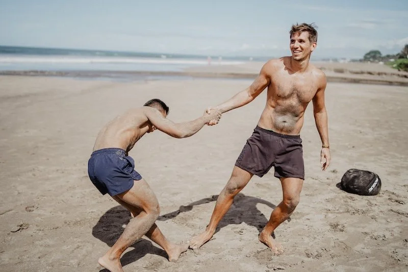 Community und gegenseitige Unterstützung beim Sport, wie hier bei einem Strand Workout auf Bali