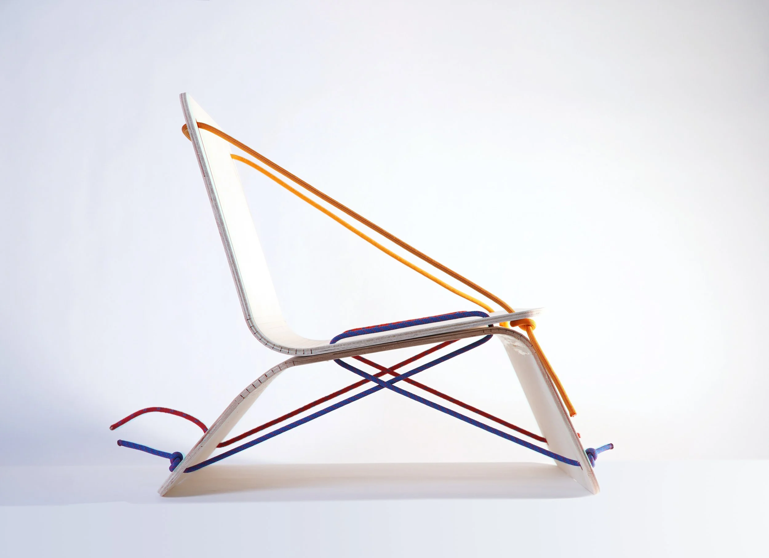 A row of five colorful chairs stacked on top of each other against a white background.