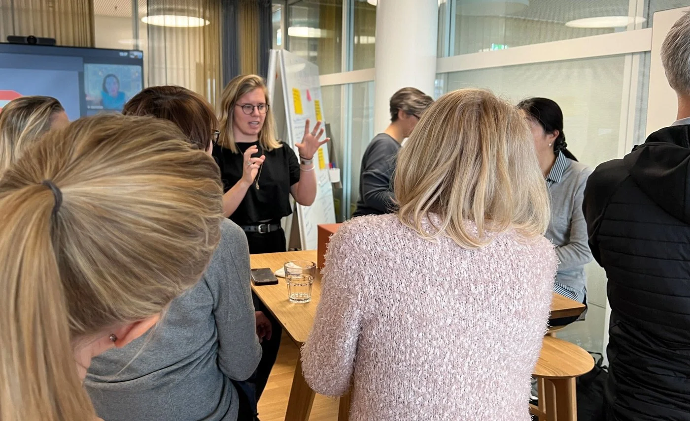 An image of Ida Persson leading a workshop. People are looking at her as she speaks.