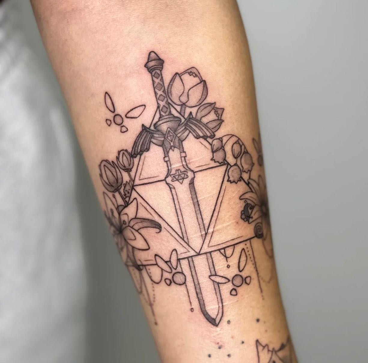 Custom master sword and triforce ⚔️ 
Apprentice work: @kaldrae.ink 
________________________________________________
[At Off the Ground Ink, we bring your tattoo ideas to life! 💭 For bookings and inquiries, reach out to us by email at offthegroundin