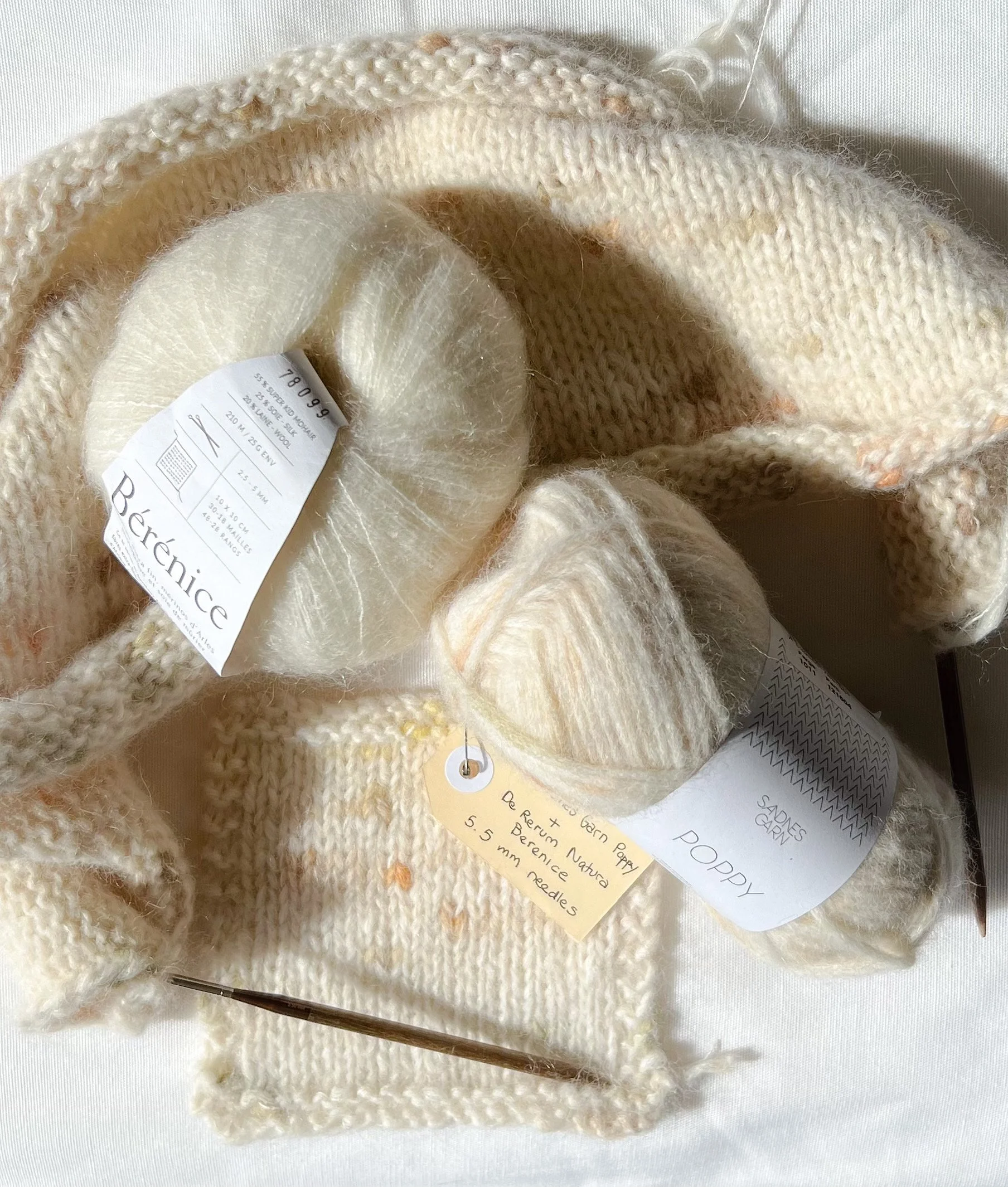 Creamy coloured years and some knitting with wooden needles.