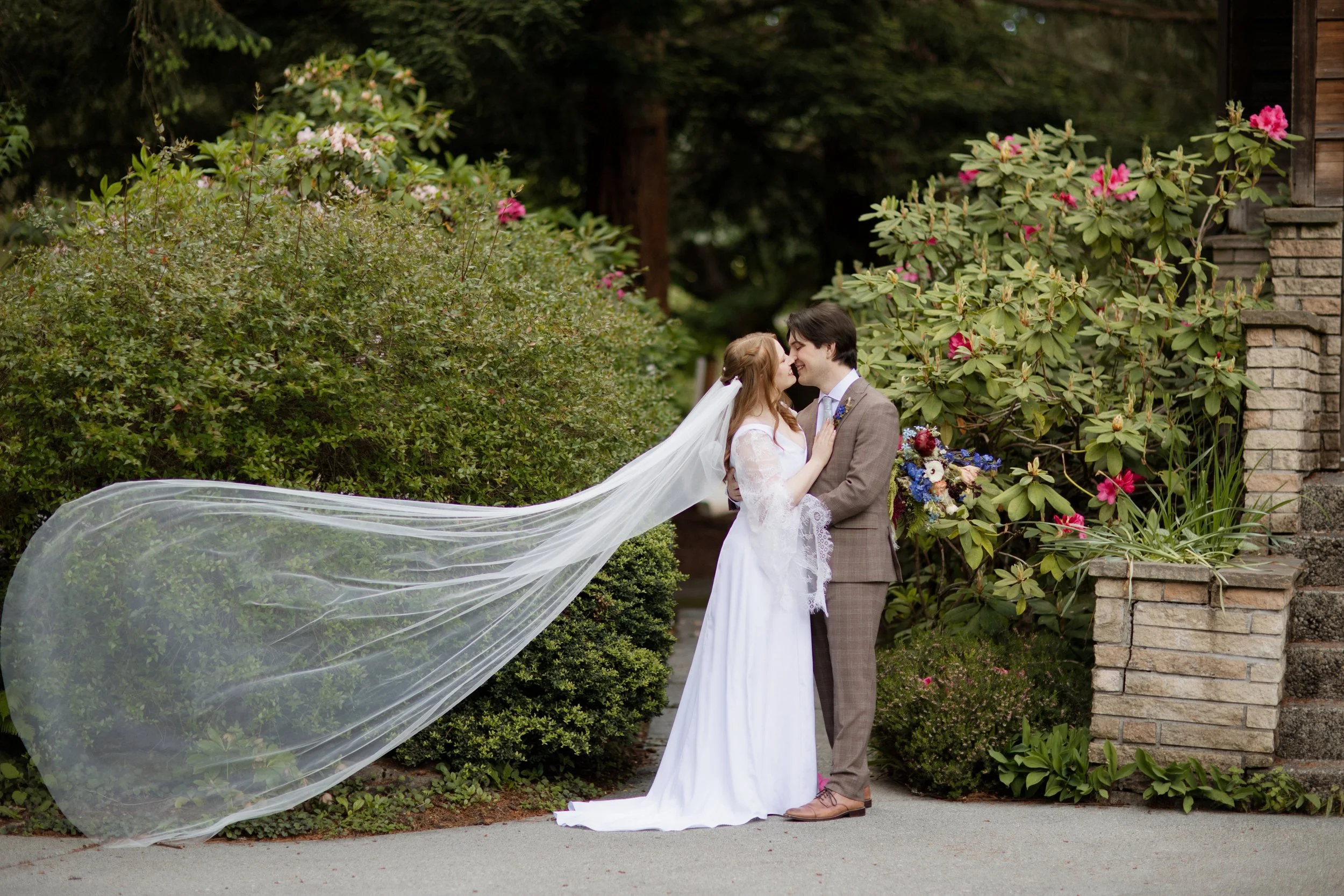 bride vail shoot during romantic portrait with groom