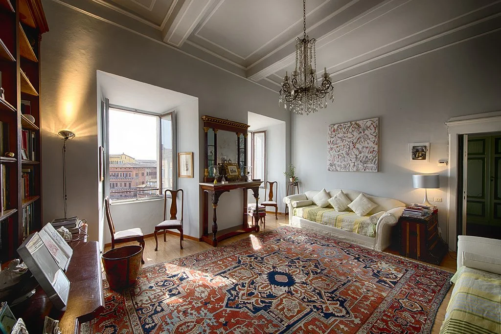 Indoor view of a cozy living room and dining area in an apartment available for rental during the Palio of Siena