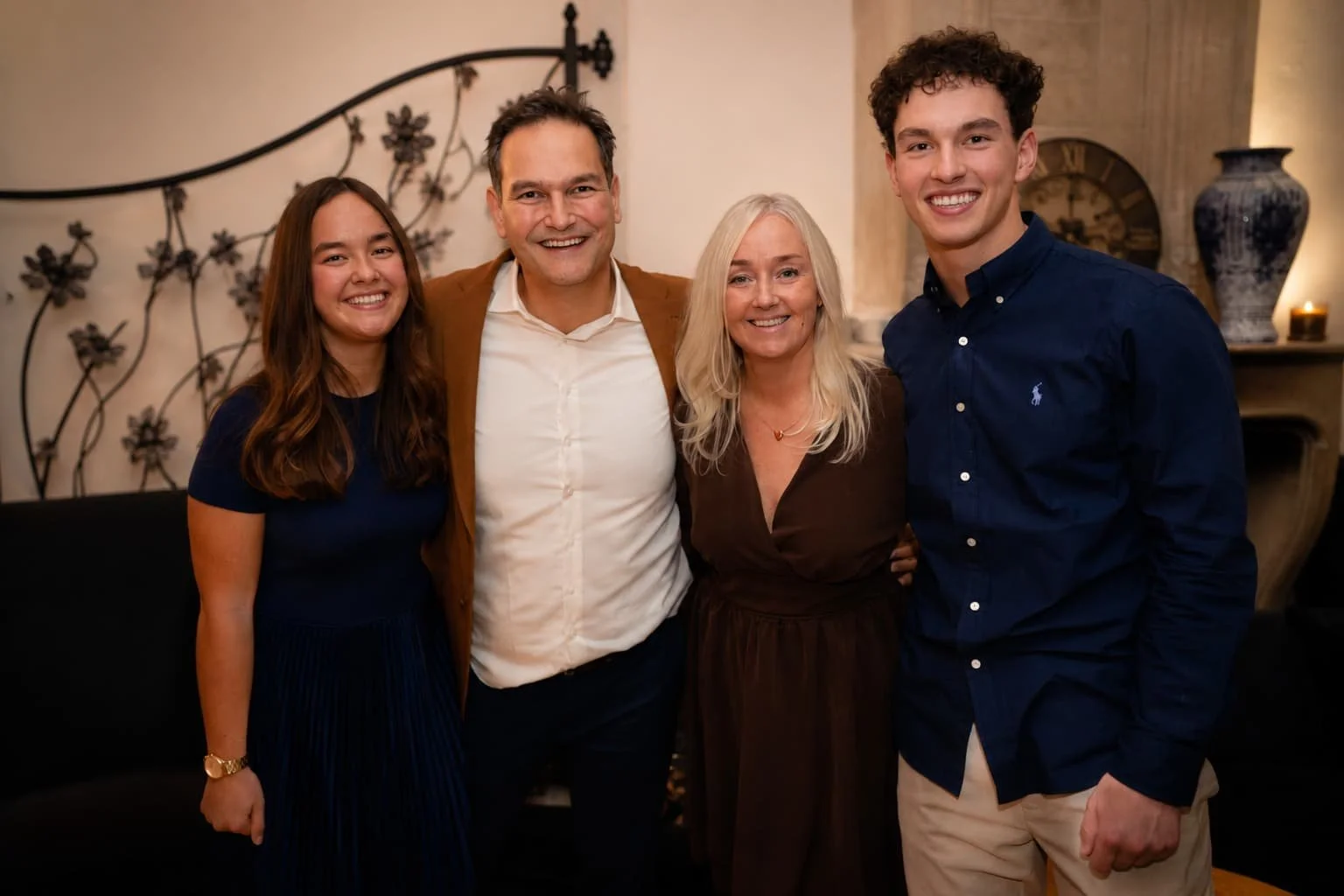 Vier mensen die glimlachend op een feestje poseerden in een gezellige kamer.