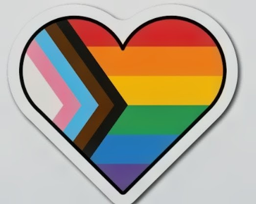 A heart-shaped sticker with rainbow pride colors, including the transgender pride flag with pink, light blue, and white stripes, and other rainbow stripes.