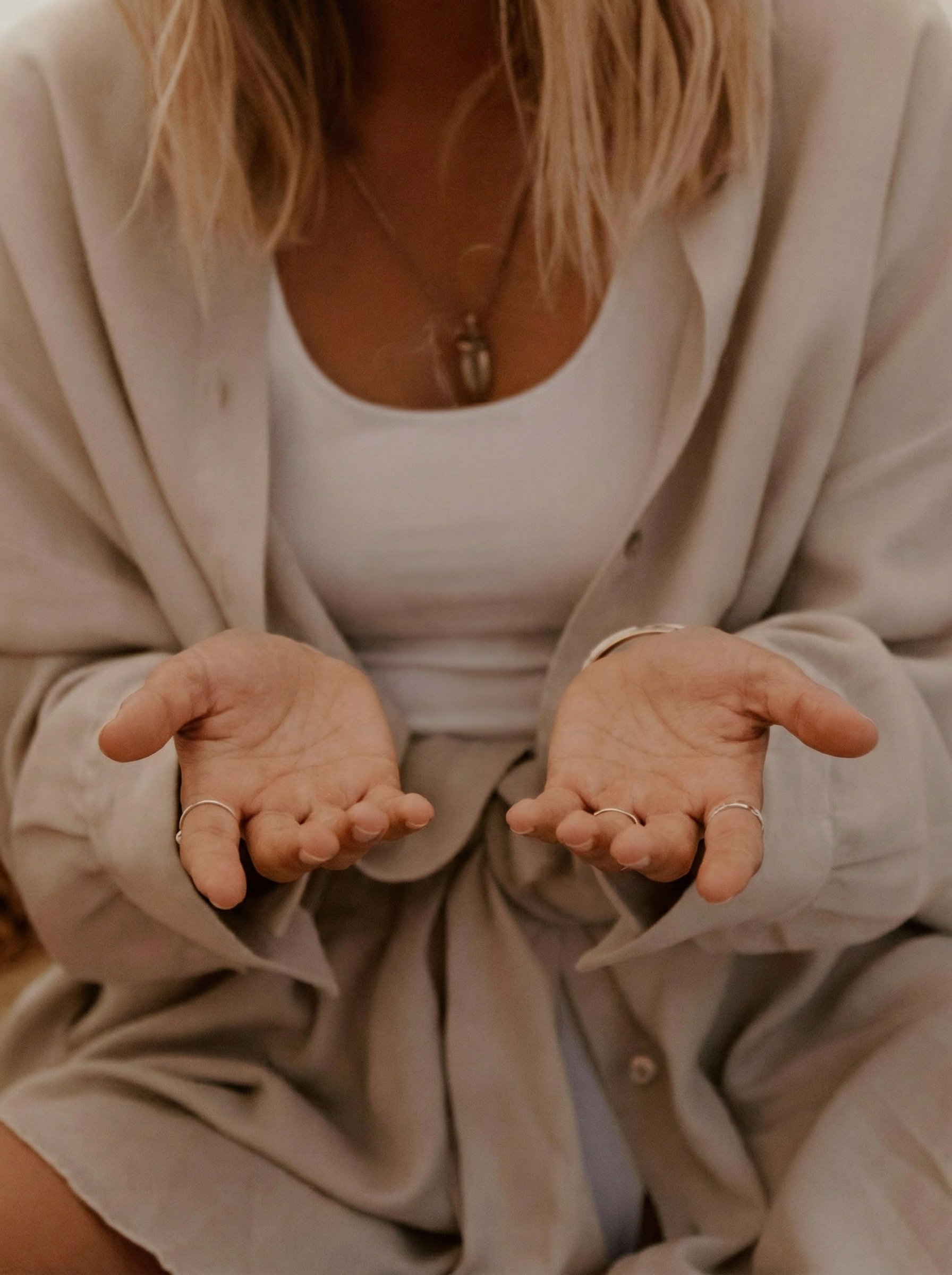 Frau mit geöffneten Händen in verkörperter Präsenz – Symbol für Energiearbeit, Raumhalten und Embodied Healer Ausbildung.
