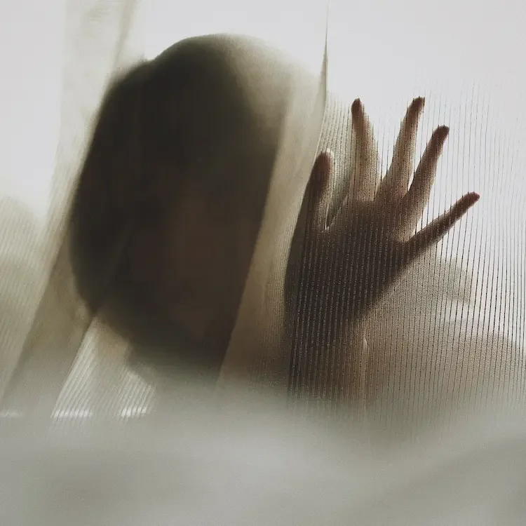 Silhouette einer Person hinter einem transparenten Vorhang während einer ruhigen Breathwork-Praxis