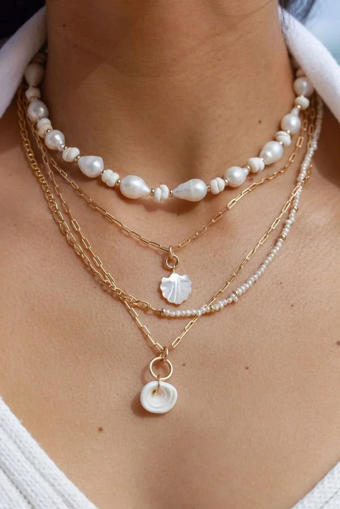 Layered coastal pearl and gold necklaces