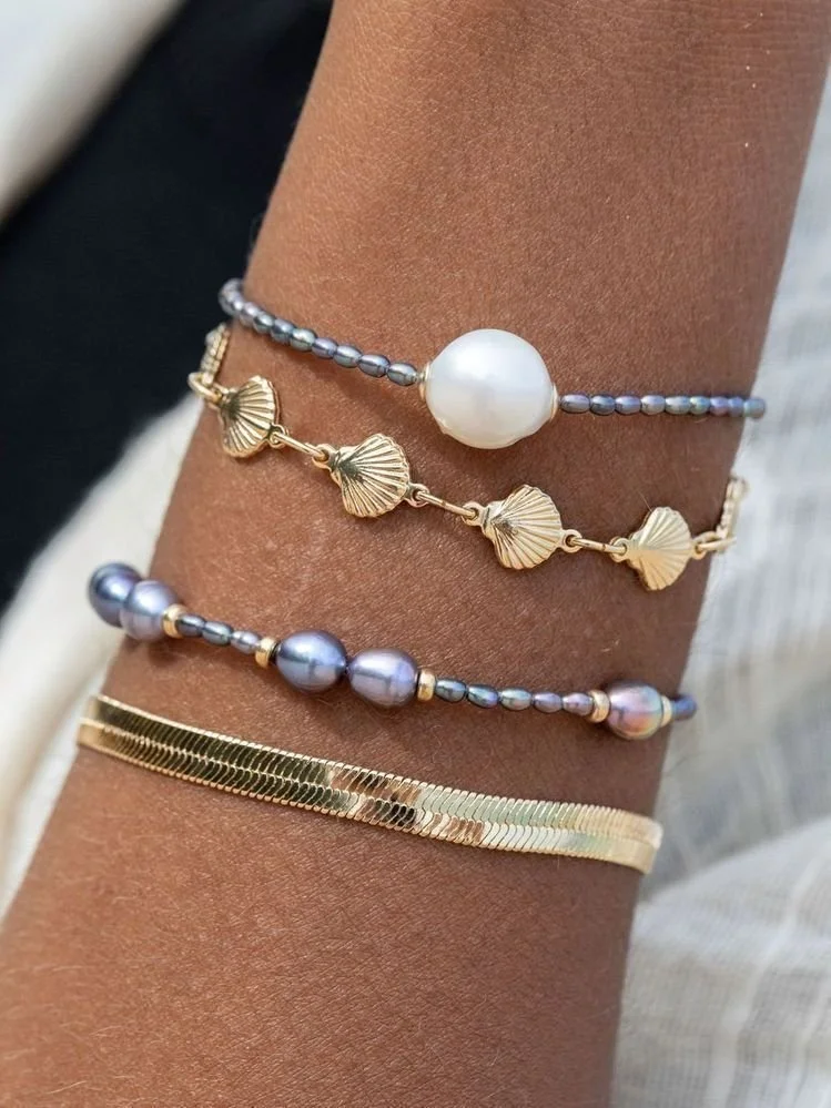 Layered coastal pearl and gold bracelets