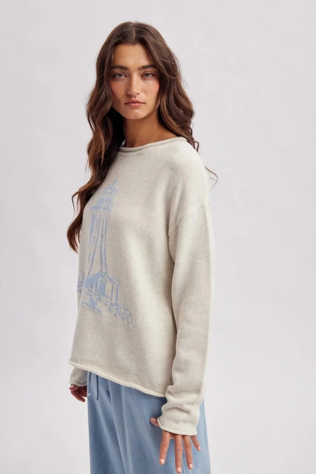 Ivory lighthouse sweater with light blue coastal lighthouse design, a nautical knit.