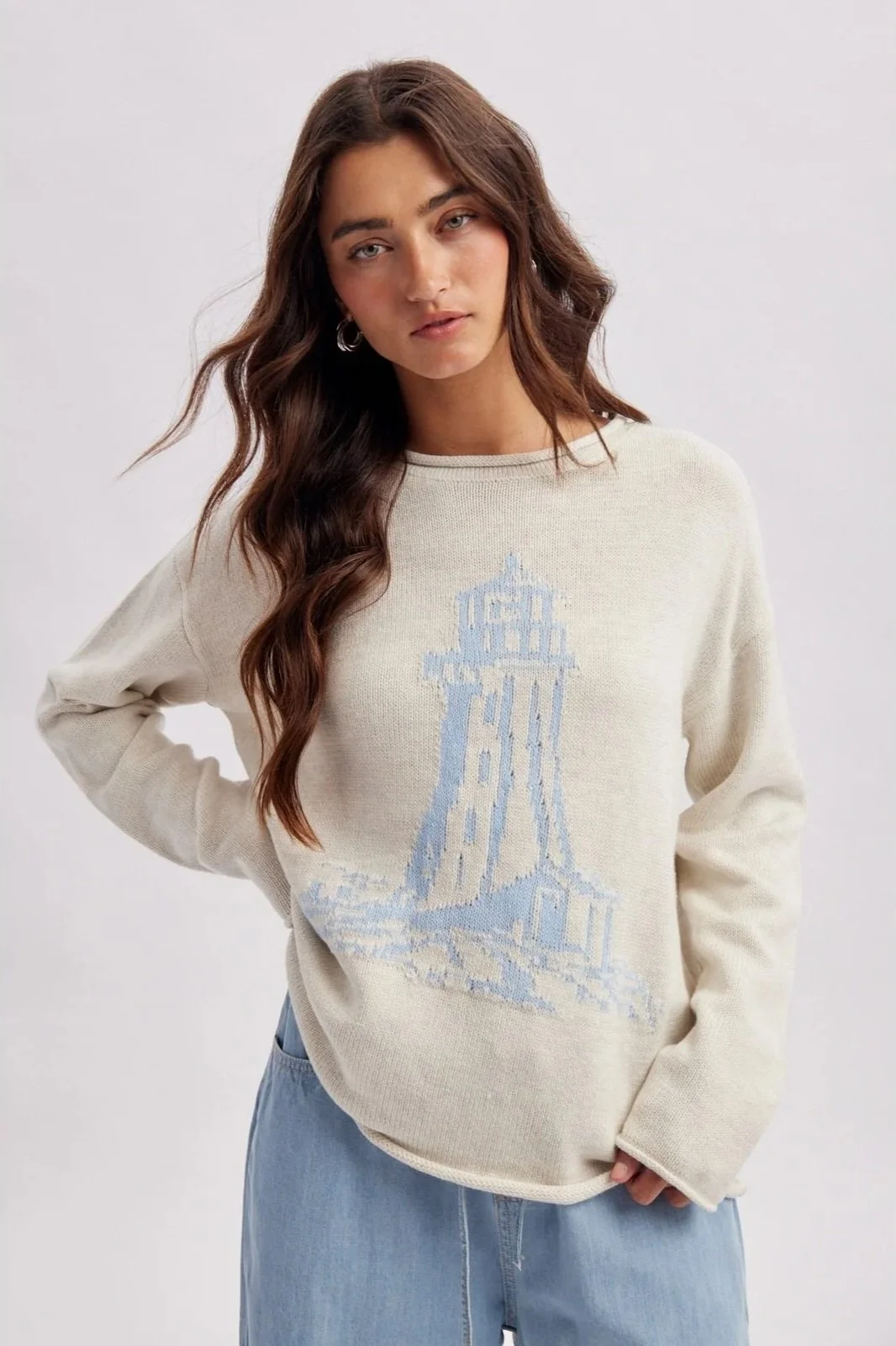 Ivory lighthouse sweater with light blue coastal lighthouse design, a nautical knit.