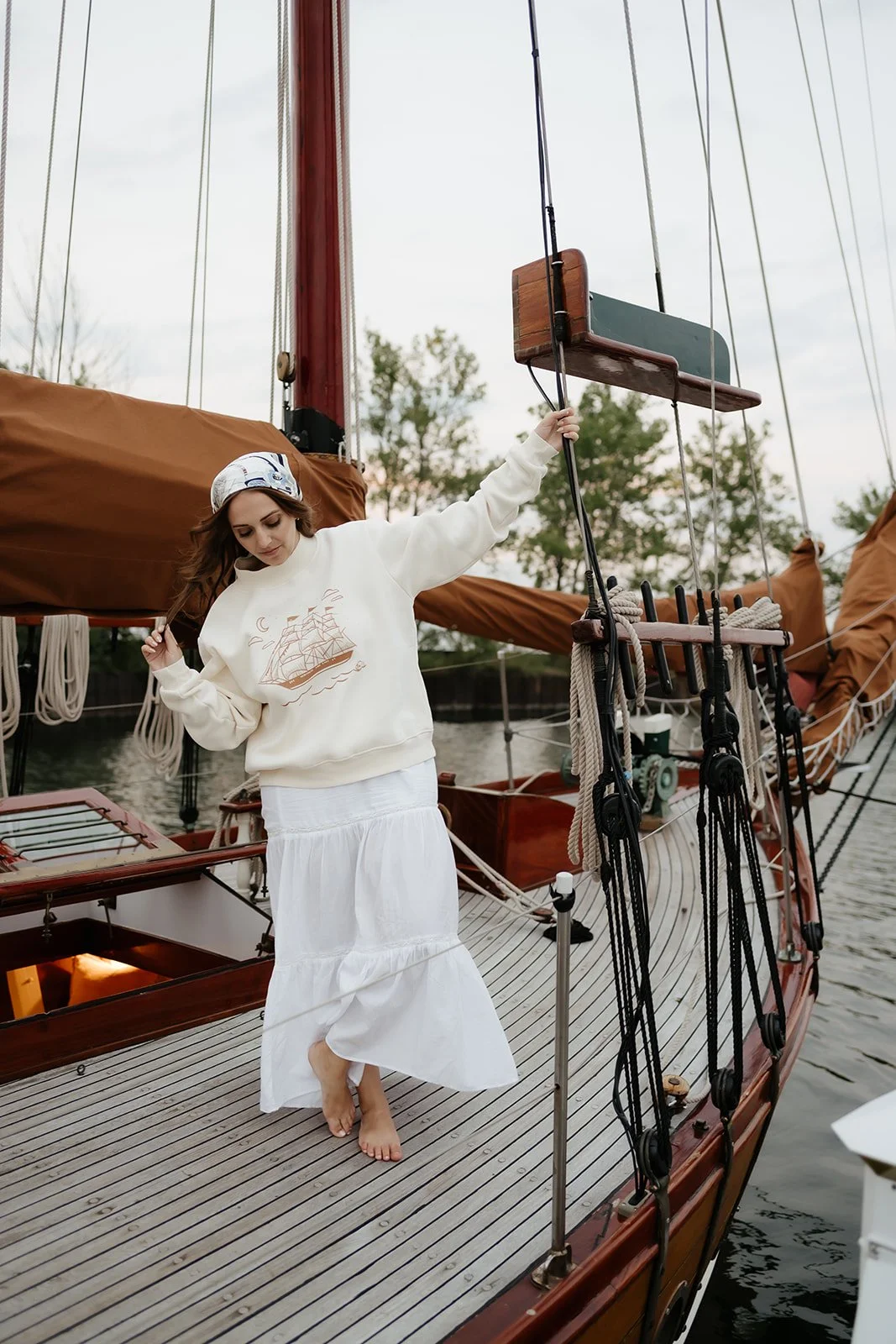 Ivory women’s Ghost Ship mockneck sweatshirt featuring a vintage sailing ship, crescent moon and skull graphic, a coastal Halloween sweatshirt for fall.