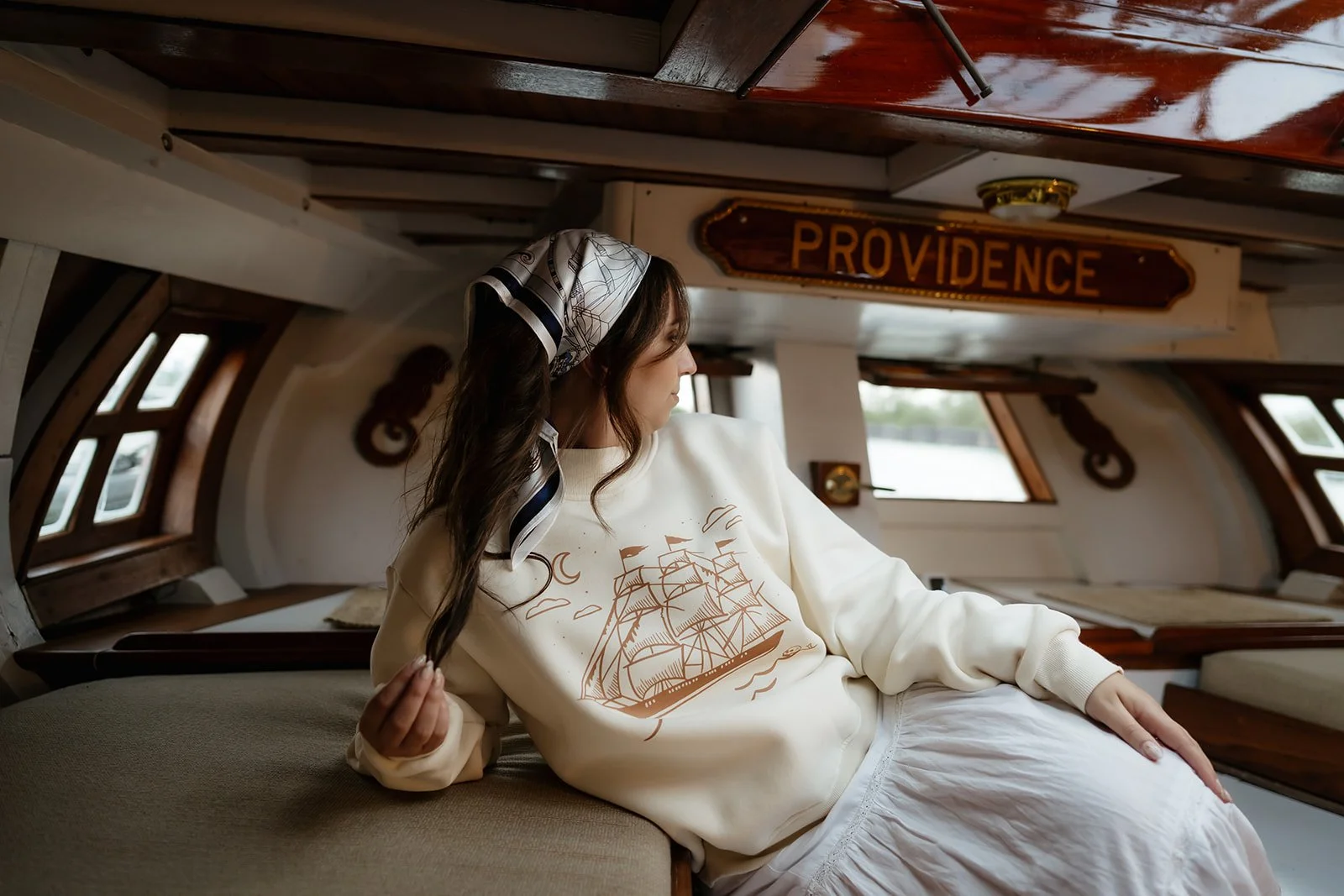 Ivory women’s Ghost Ship mockneck sweatshirt featuring a vintage sailing ship, crescent moon and skull graphic, a coastal Halloween sweatshirt for fall.