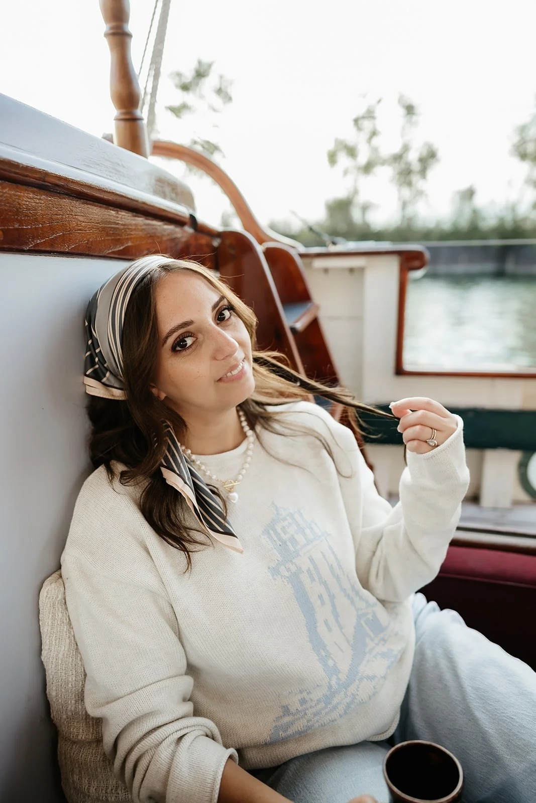 Ivory lighthouse sweater with light blue coastal lighthouse design, a nautical knit.