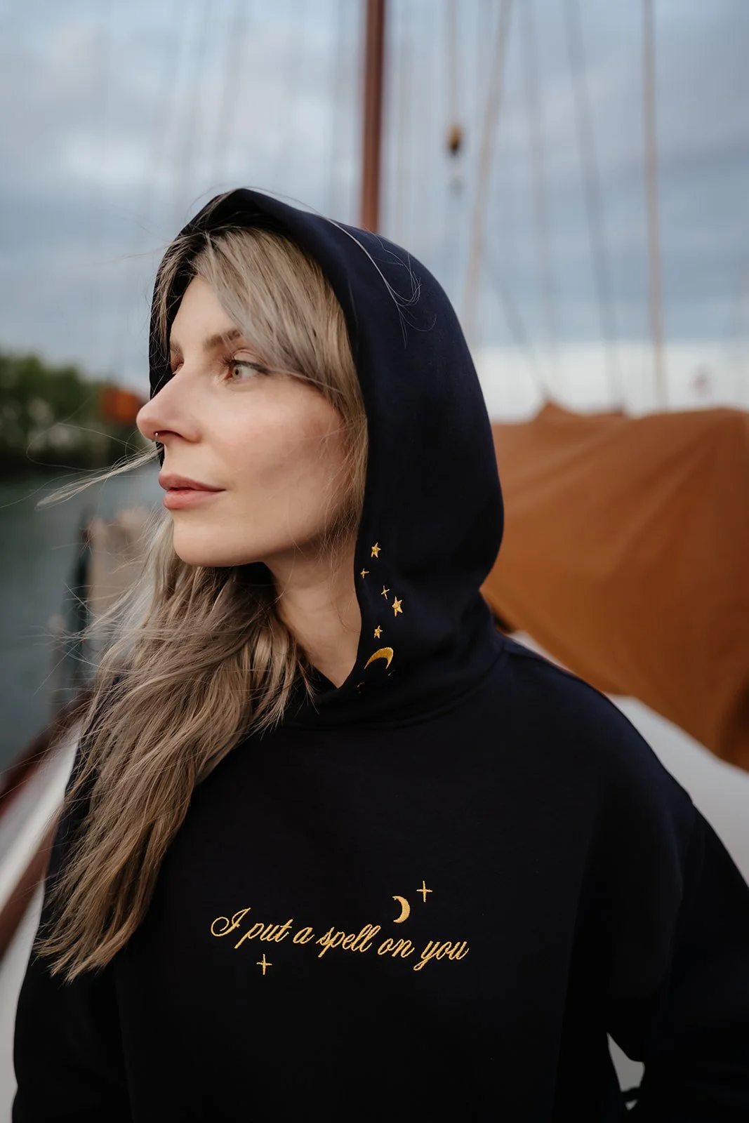 Navy witchy graphic hoodie for fall and Halloween featuring a celestial wheel of fortune design with gold moon, stars, constellations and compass details.