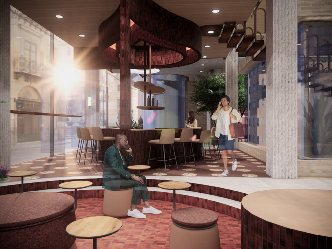 Interior of The Visionaire café with two men, one sitting on a rounded stool using a phone and another walking with a bag and talking on a phone.