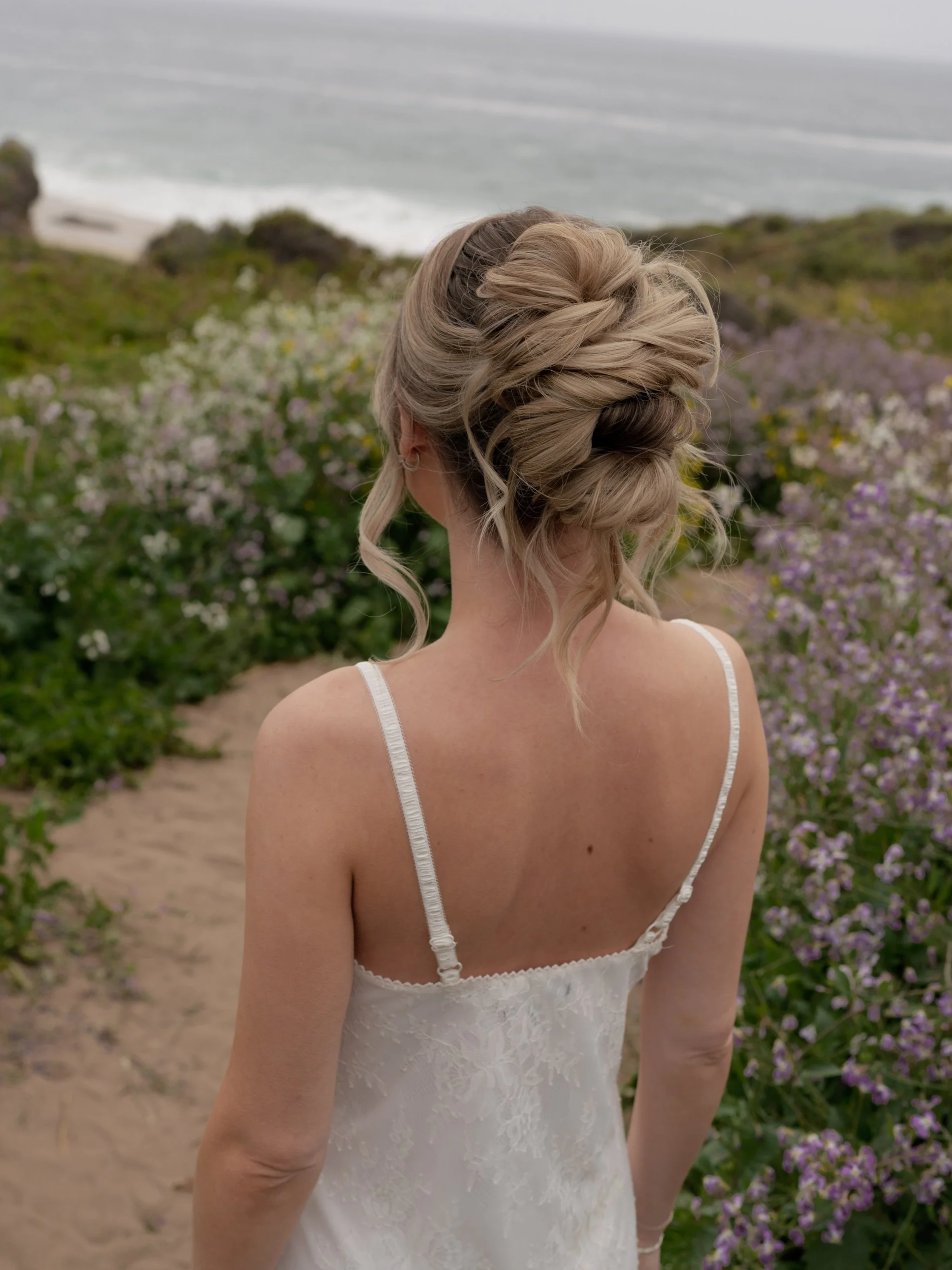 Woman with brown hair and light blue eyes having makeup applied by a makeup artist.