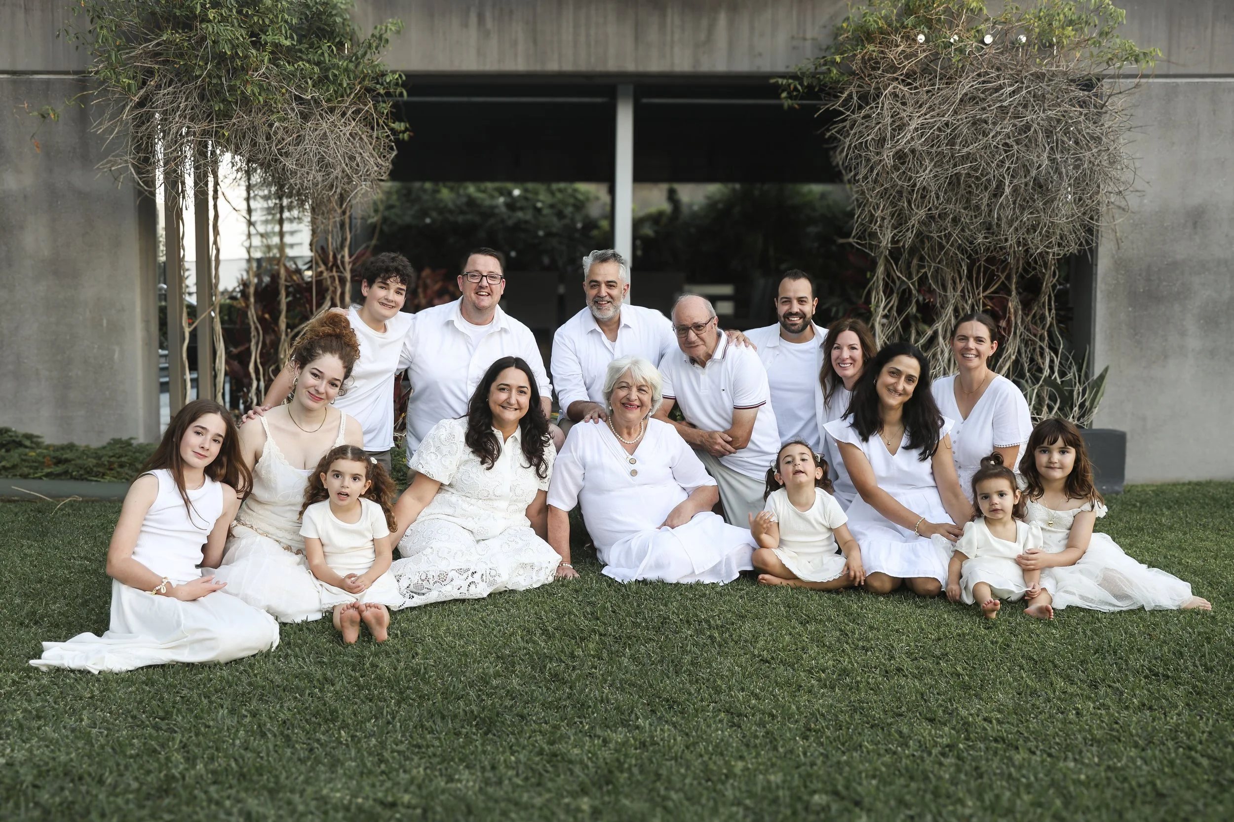 A beautiful, multi-generational family group portrait taken during a relaxed outdoor photography session on the lush resort grounds at Peppers Salt Resort & Spa in Broadbeach, Gold Coast.