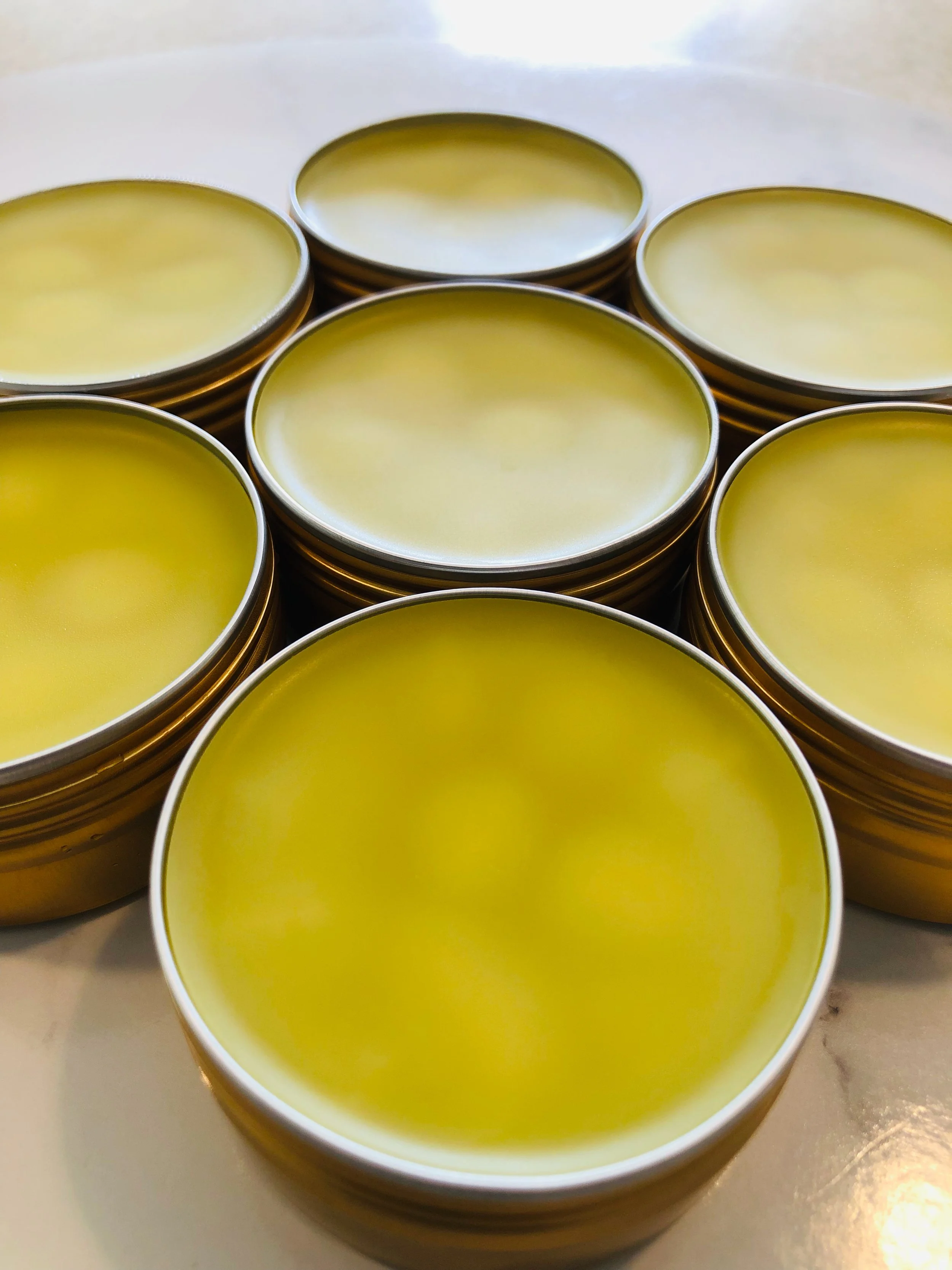 Close-up view of several stacked metal tins with yellow content inside.