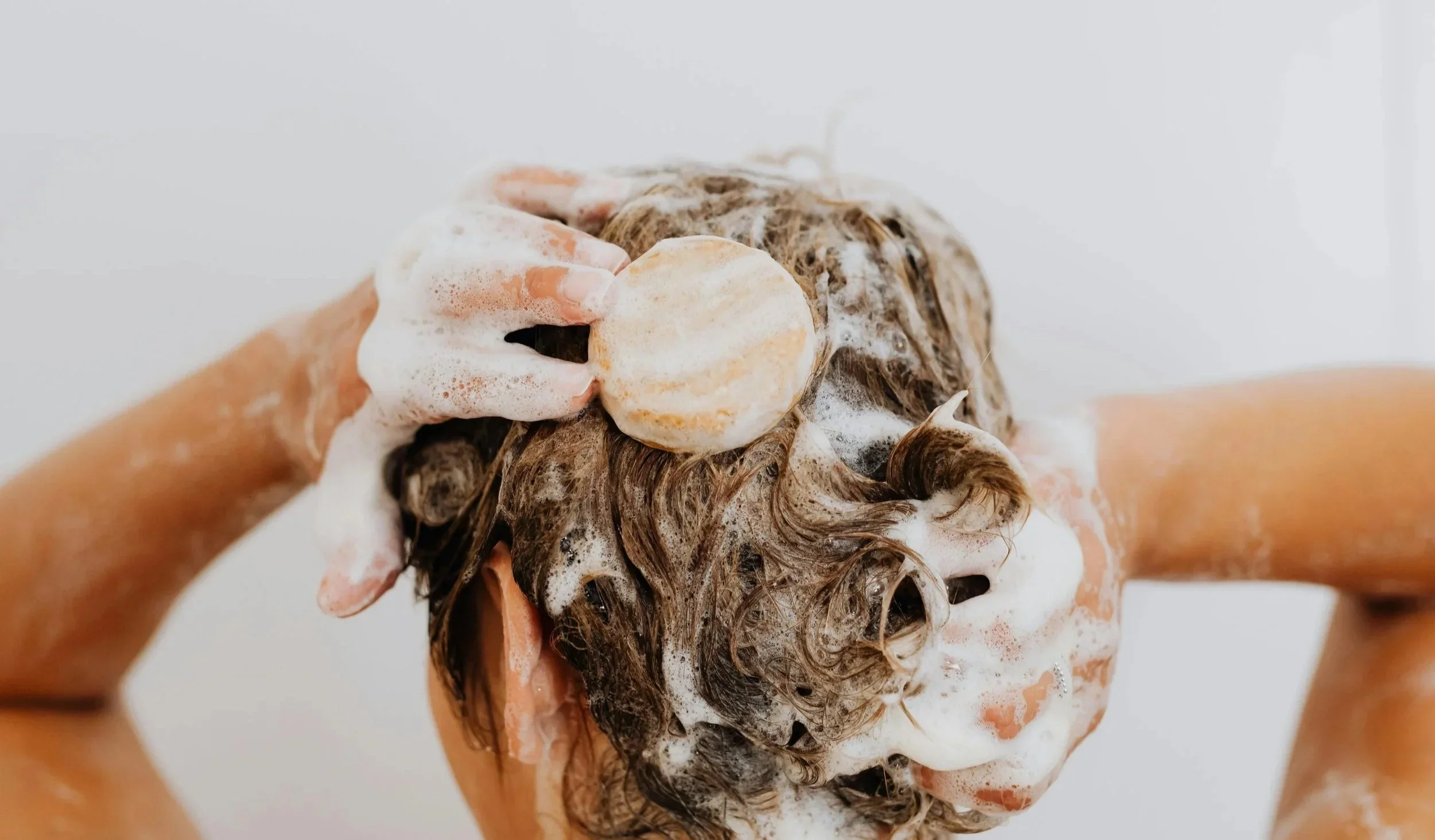 lady using solid shampoo bar in the shower, NZ