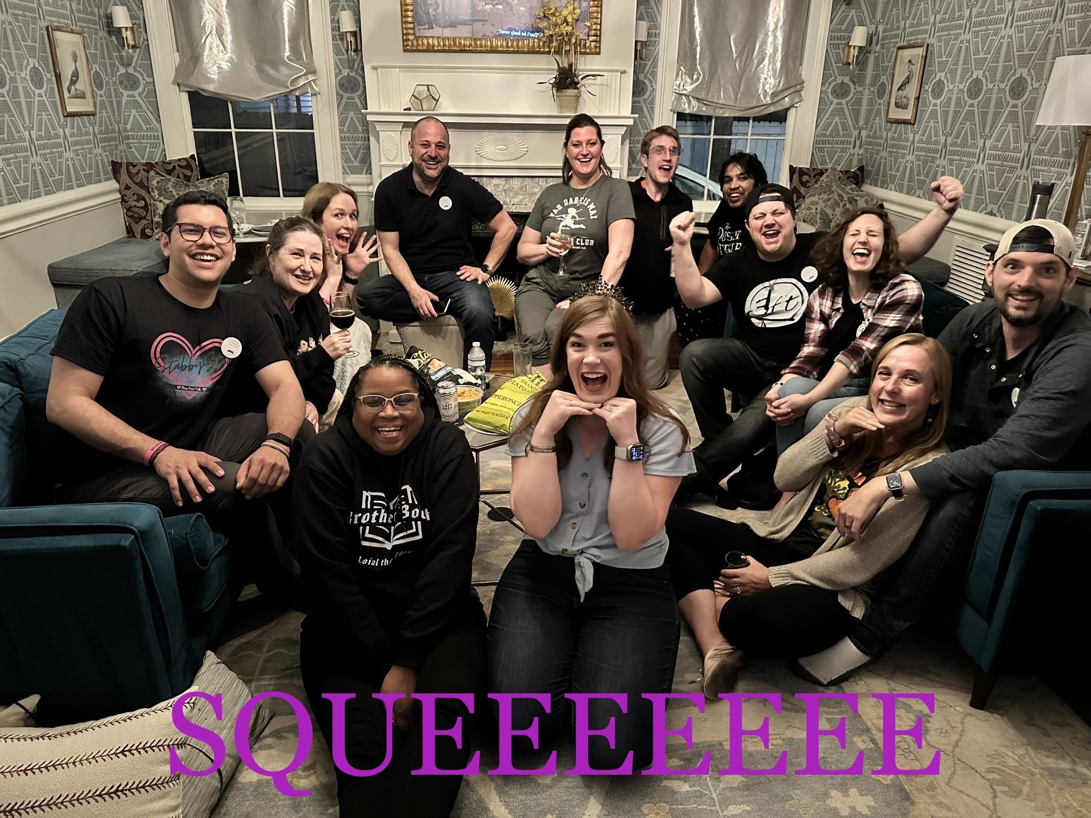 13 wheel of time fans sit on couches and chairs in a mansion living room, in various states of "squee." Sharnise and Kritter kneel in front. At the bottom of the photo is the word "Squeeeeeee" in hot pink capital letters