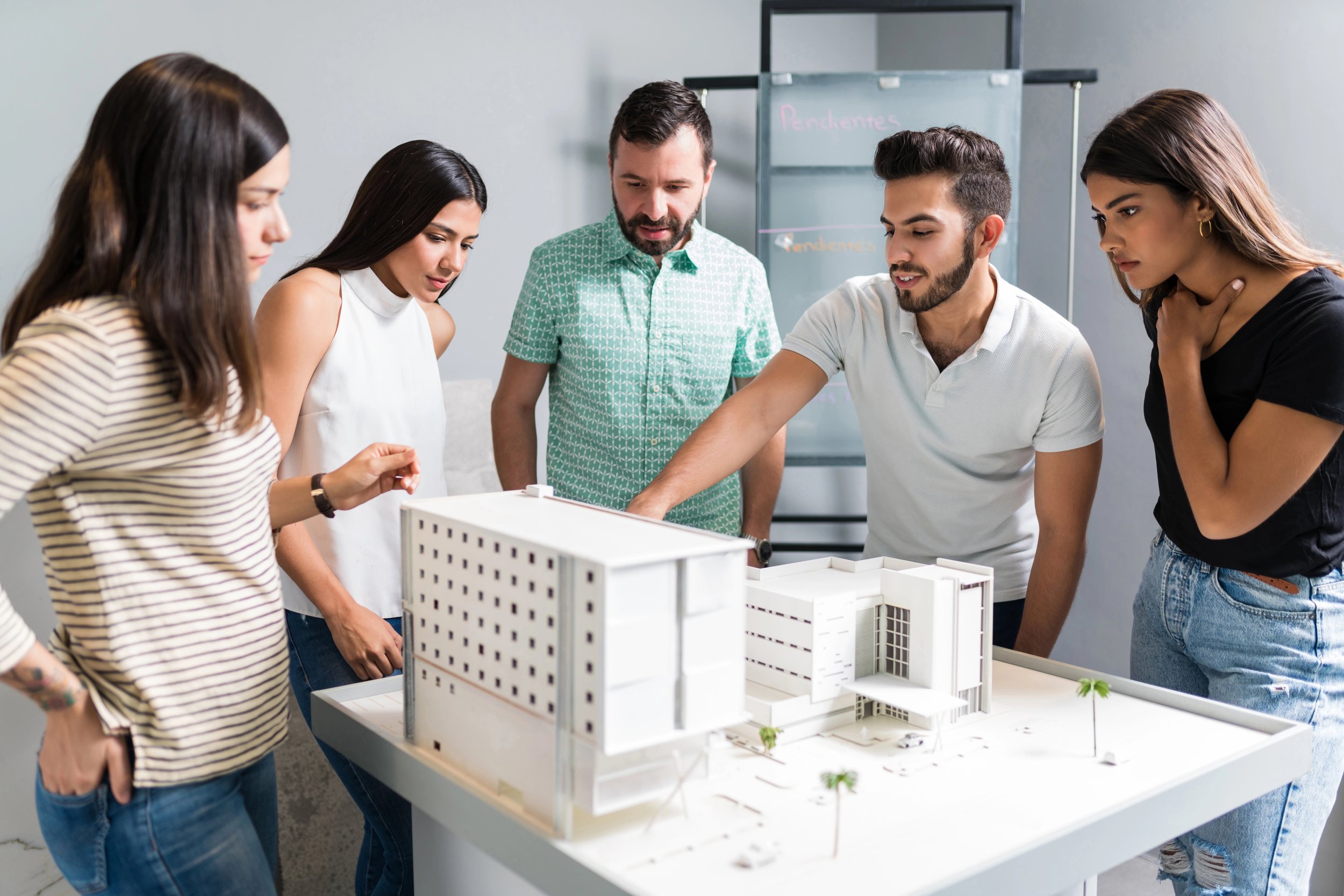 Team of Hispanic/Latino property investors reviewing 3-D model of new building