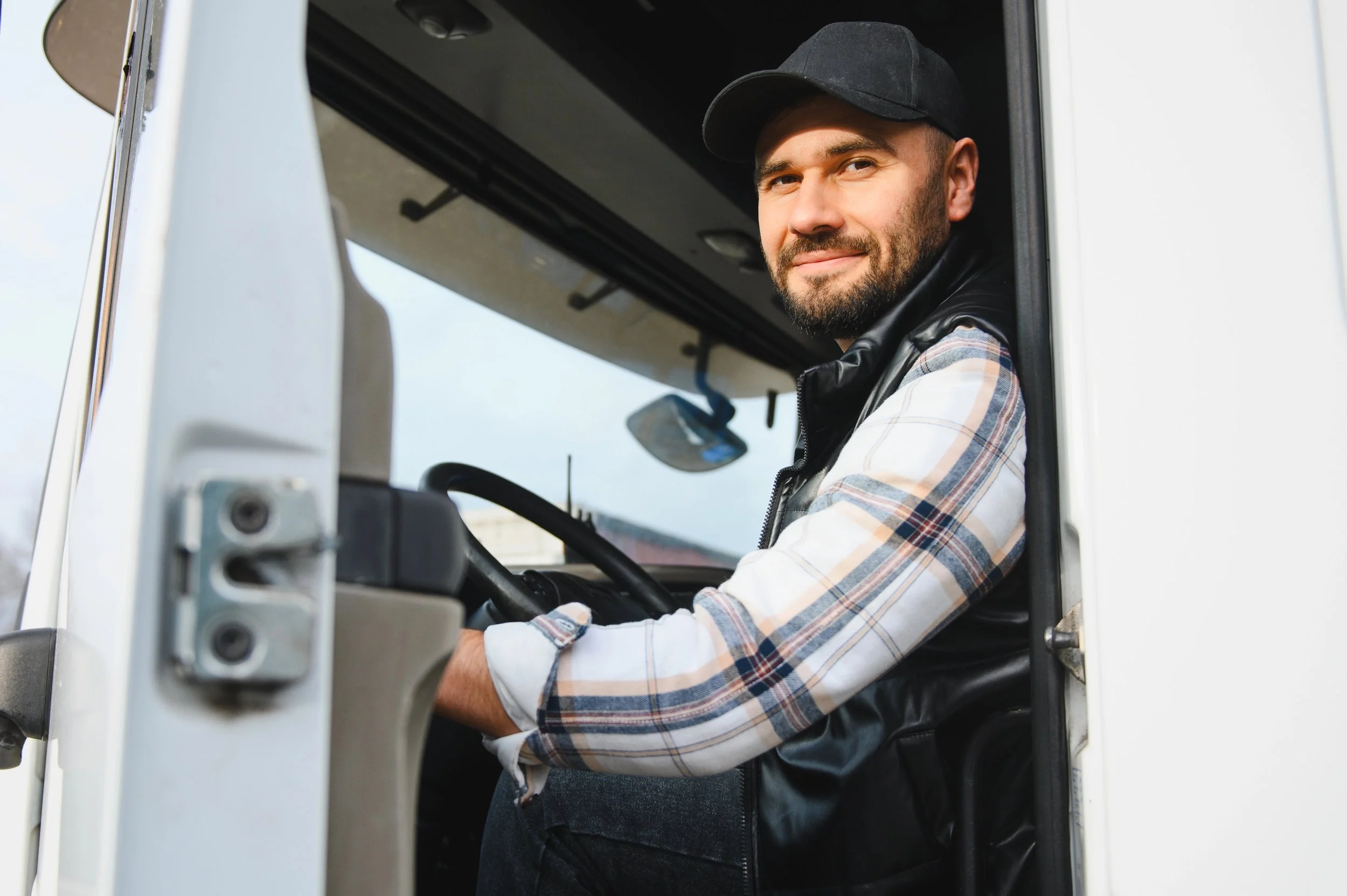 Professional truck driver sitting in cab of truck