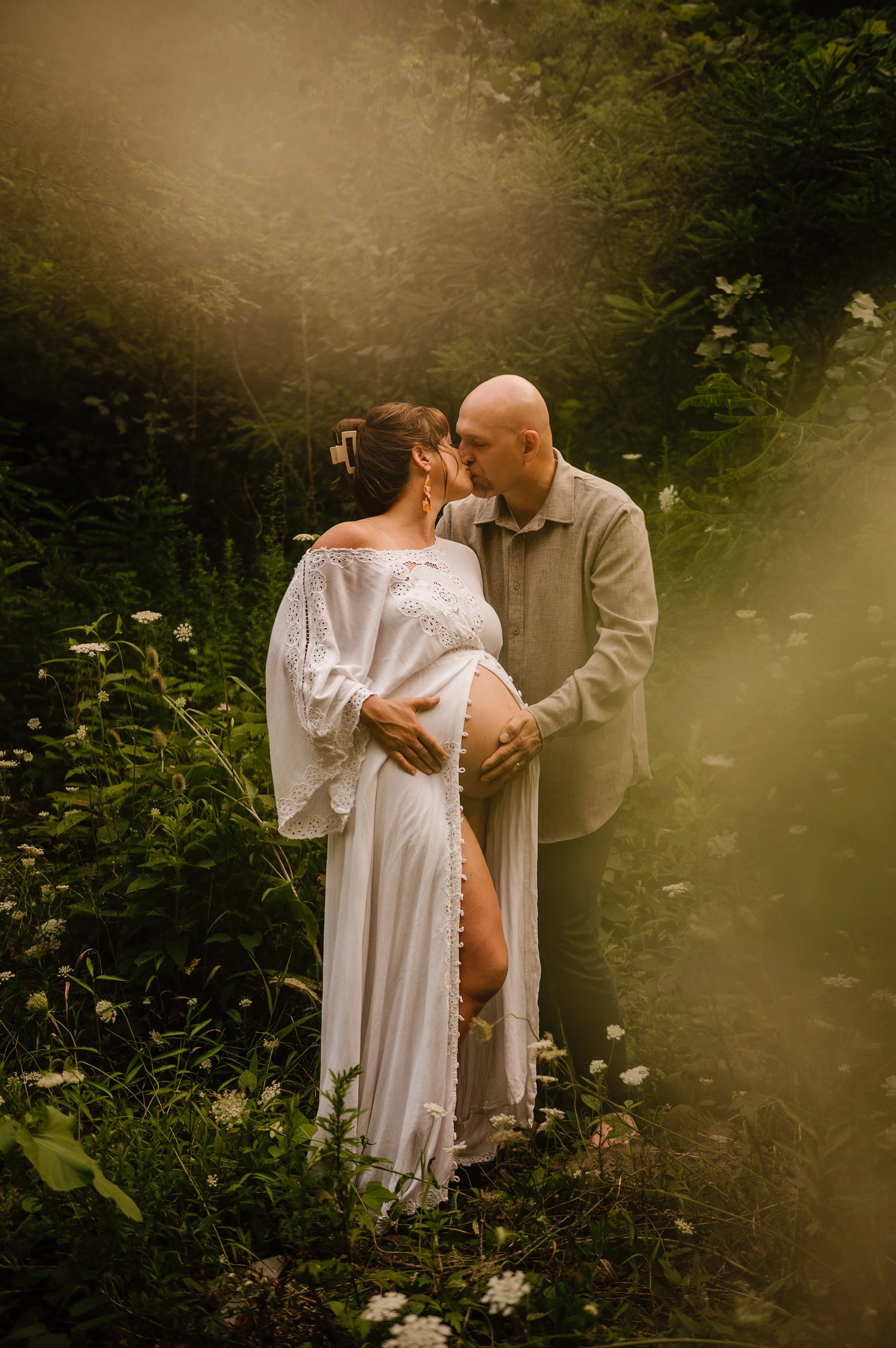couple taking maternity photos in cleveland ohio park at sunset dad holding moms belly