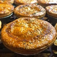 Close-up of freshly baked English muffins sprinkled with herbs and grated cheese.