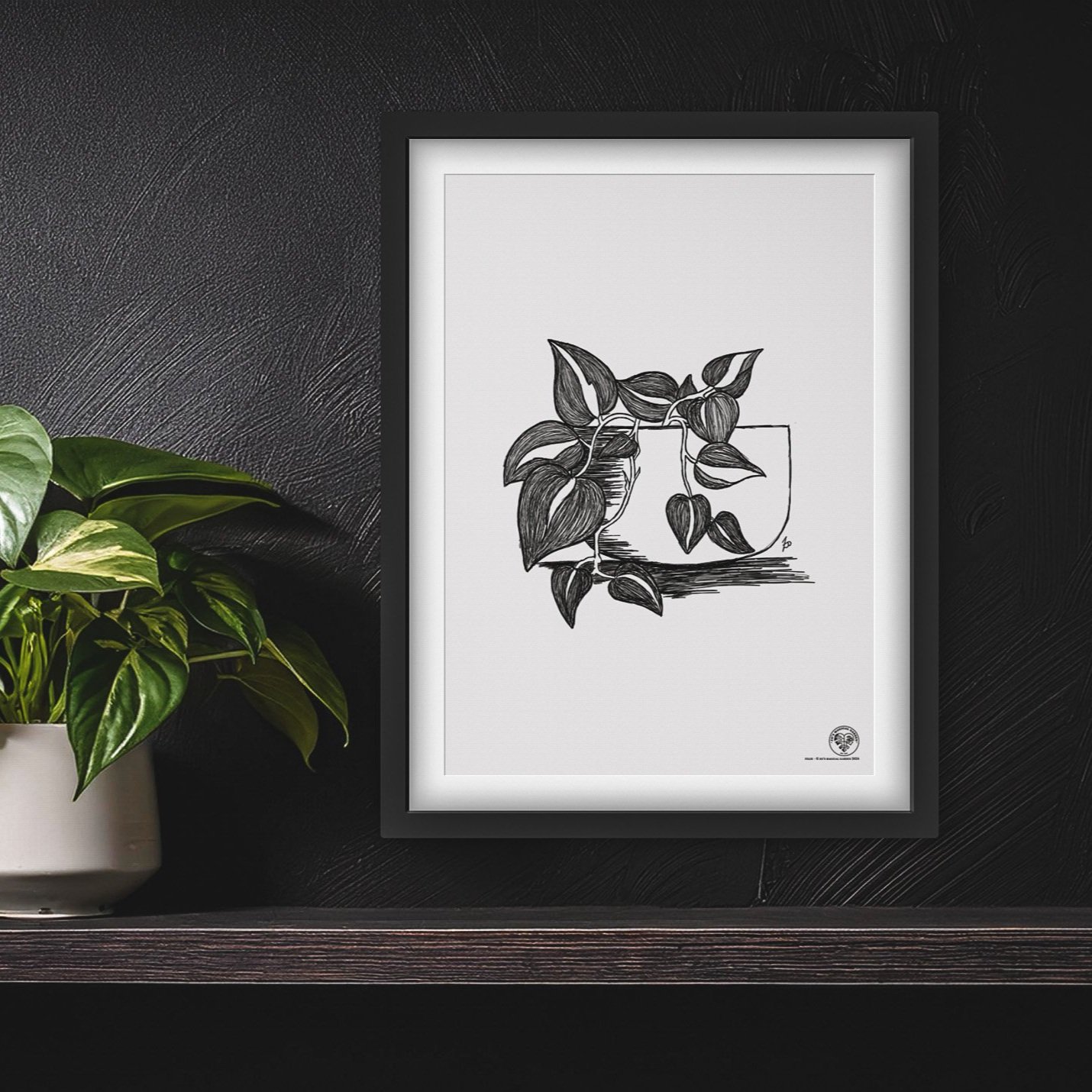 mockup of print in black frame on black wall surrounded by plants.