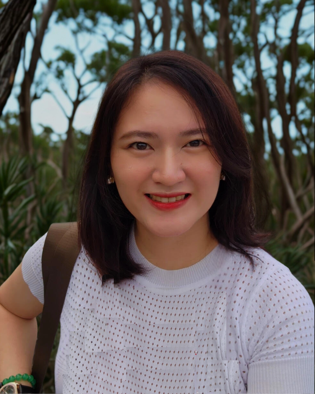 Portrait of Christine Ong, Head of Credit and Lending at Specialist Broking, smiling outdoors with trees in the background.
