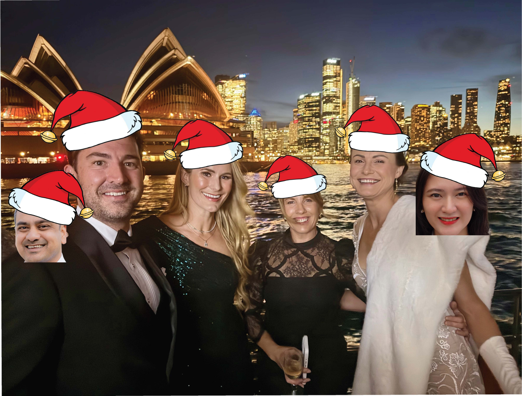 Specialist Broking team members wearing Santa hats at a festive evening event with Sydney Harbour in the background.