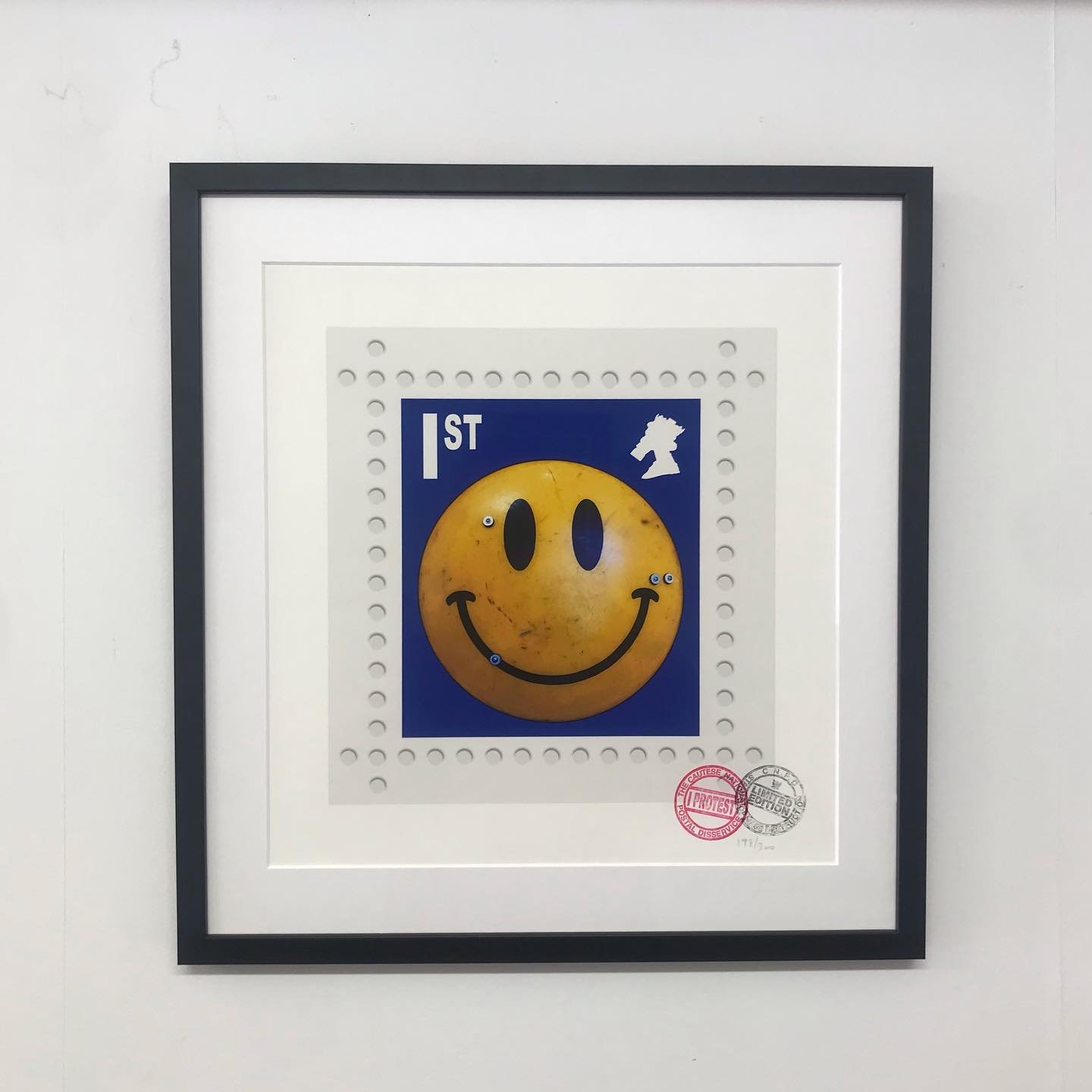 James Cauty ( Rockman Rock ) Smiley Riot Shield Stamp. 
Thin black frame, white mount, AR70 glass.
#jamescauty #rockmanrock #peterloomassacre #pictureframing #art #wallart #framing #pictures #mounting #artoftheday #glass #hangingart #farnhamframing #
