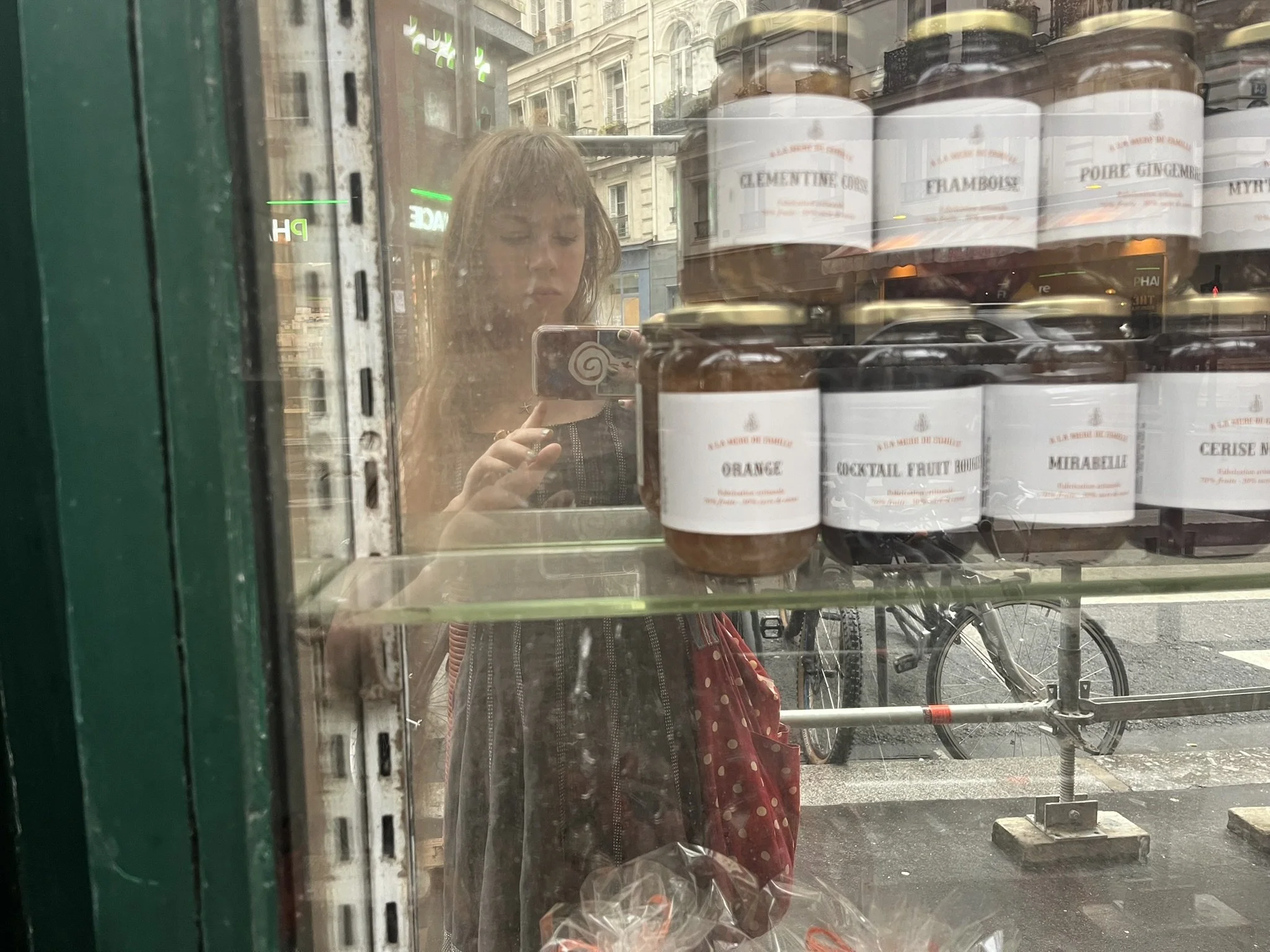 Photo of a reflection of Esther with jam jars in a window