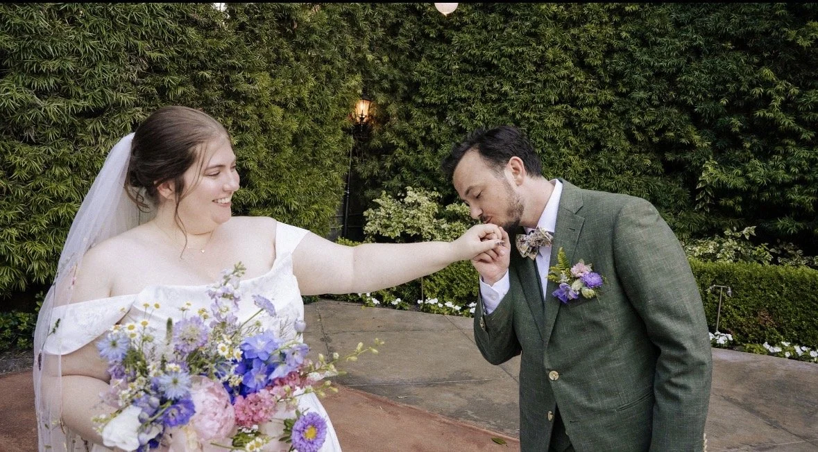 The groom kisses the brides hand in a very sweet moment