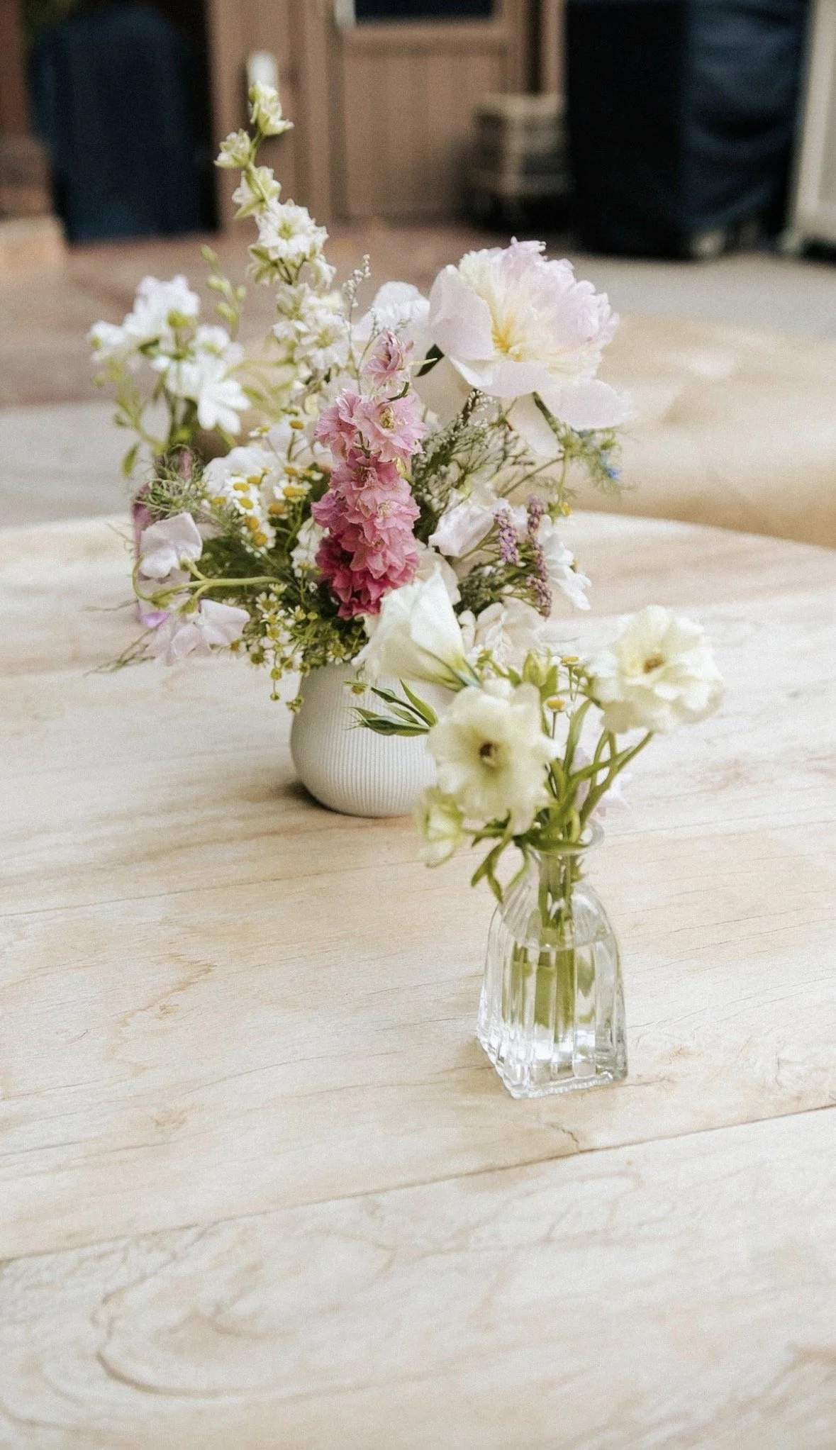 small floral arrangements and bud vases on the center of a round outdoor table at franciscan gardens