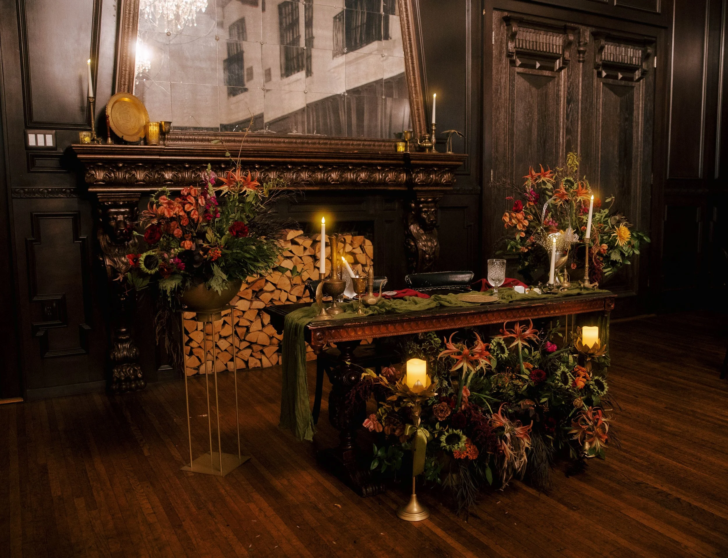 sweetheart table of dark wood with brass candlesticks, brass floral containers, and dutch masters inspired floral arrangements