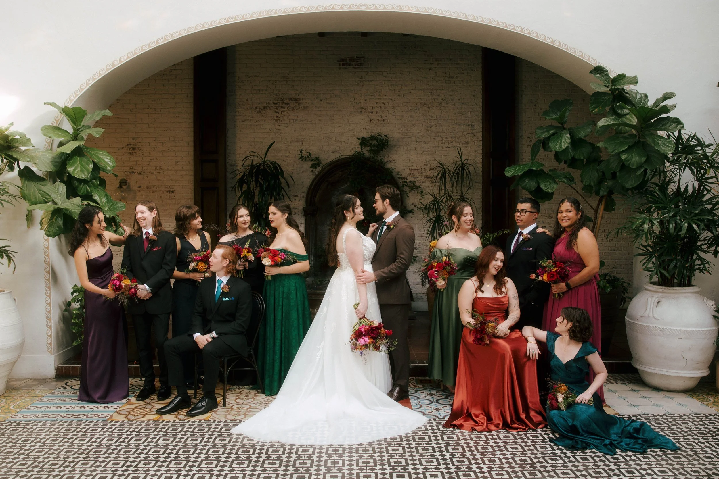 wedding party talking to each other in jewel toned dresses