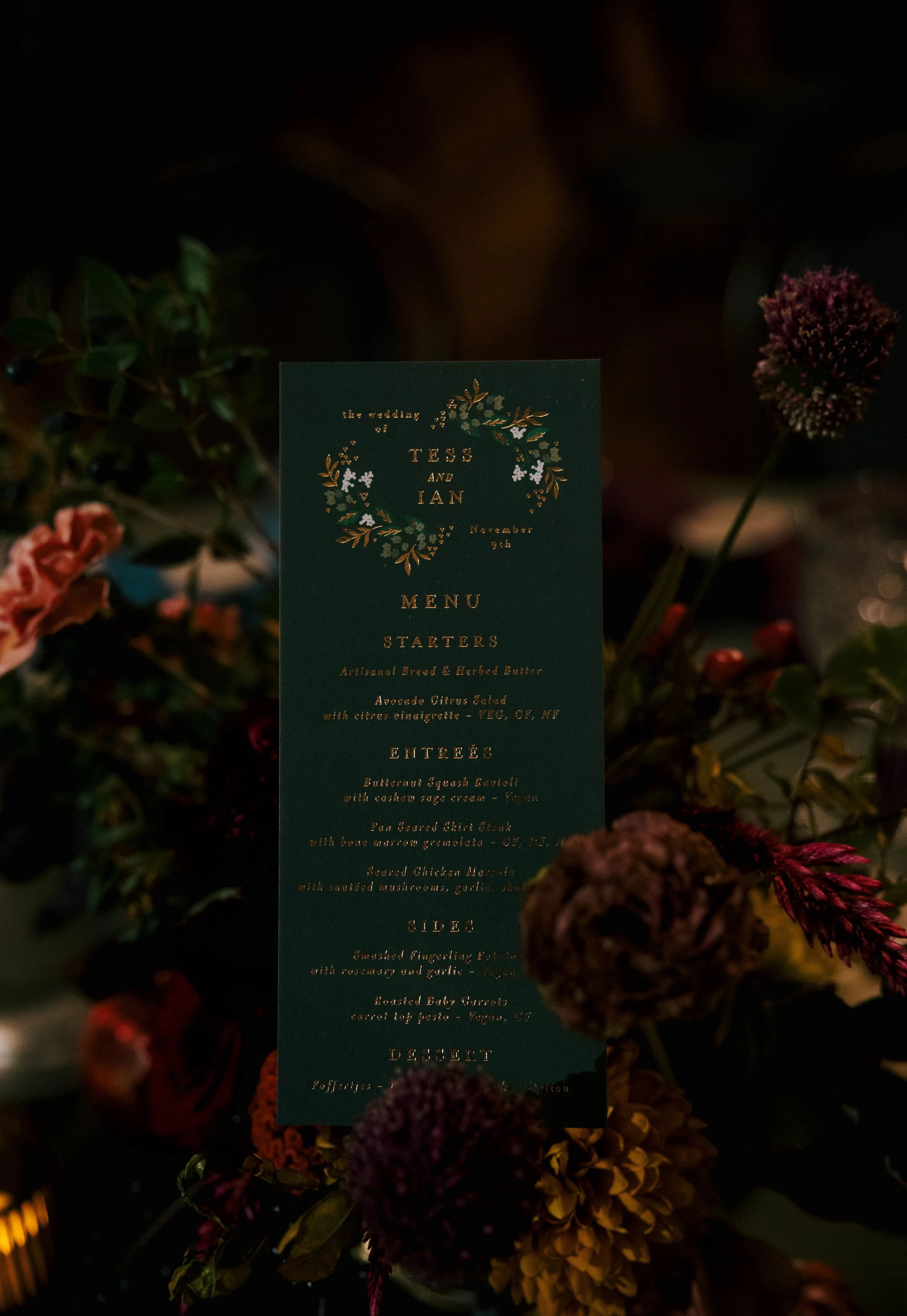 Paper menu on black matte paper with gold writing tucked into bronze and brown florals